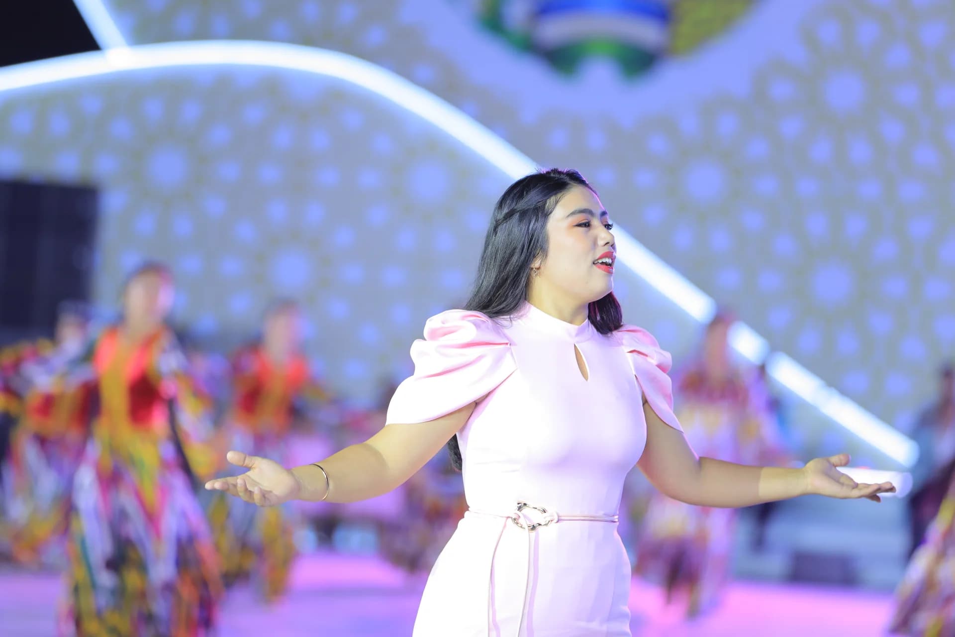 Woman performing on stage with open arms