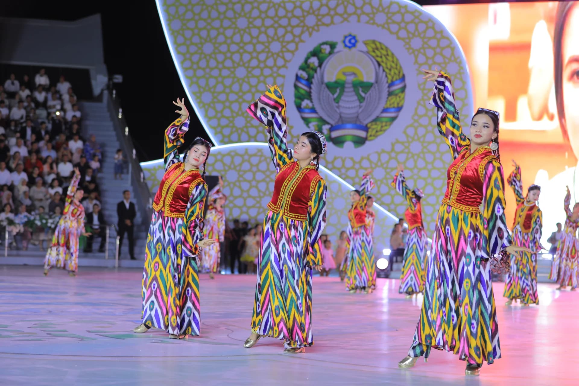 Performers in colorful traditional dresses dance on stage