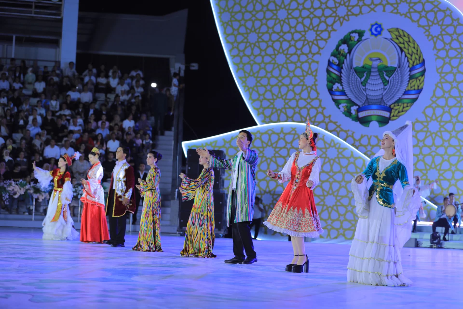 Performers in traditional clothing on a stage during an event
