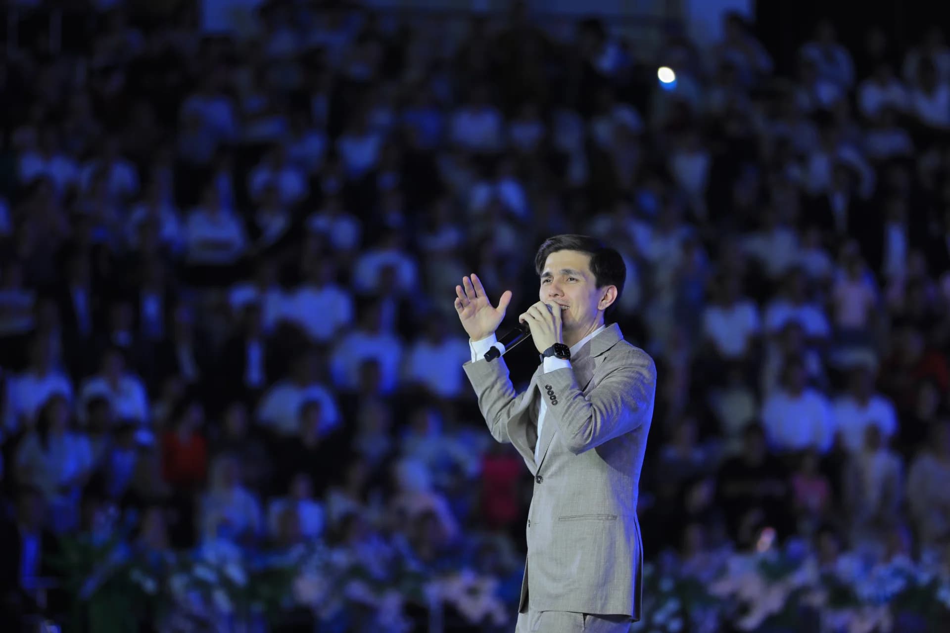 Man singing into a microphone on stage