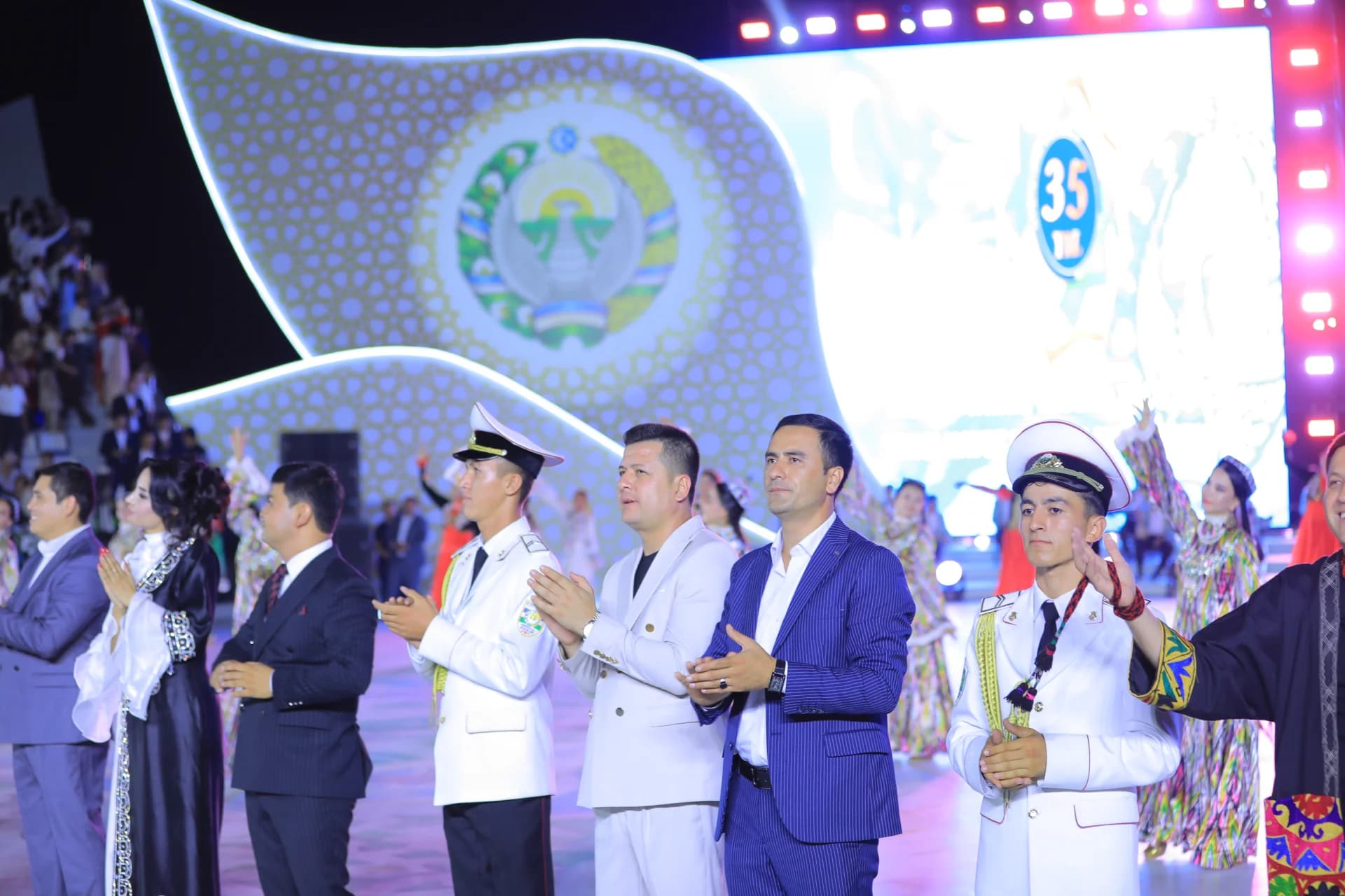 People gathered at an event with stage backdrop