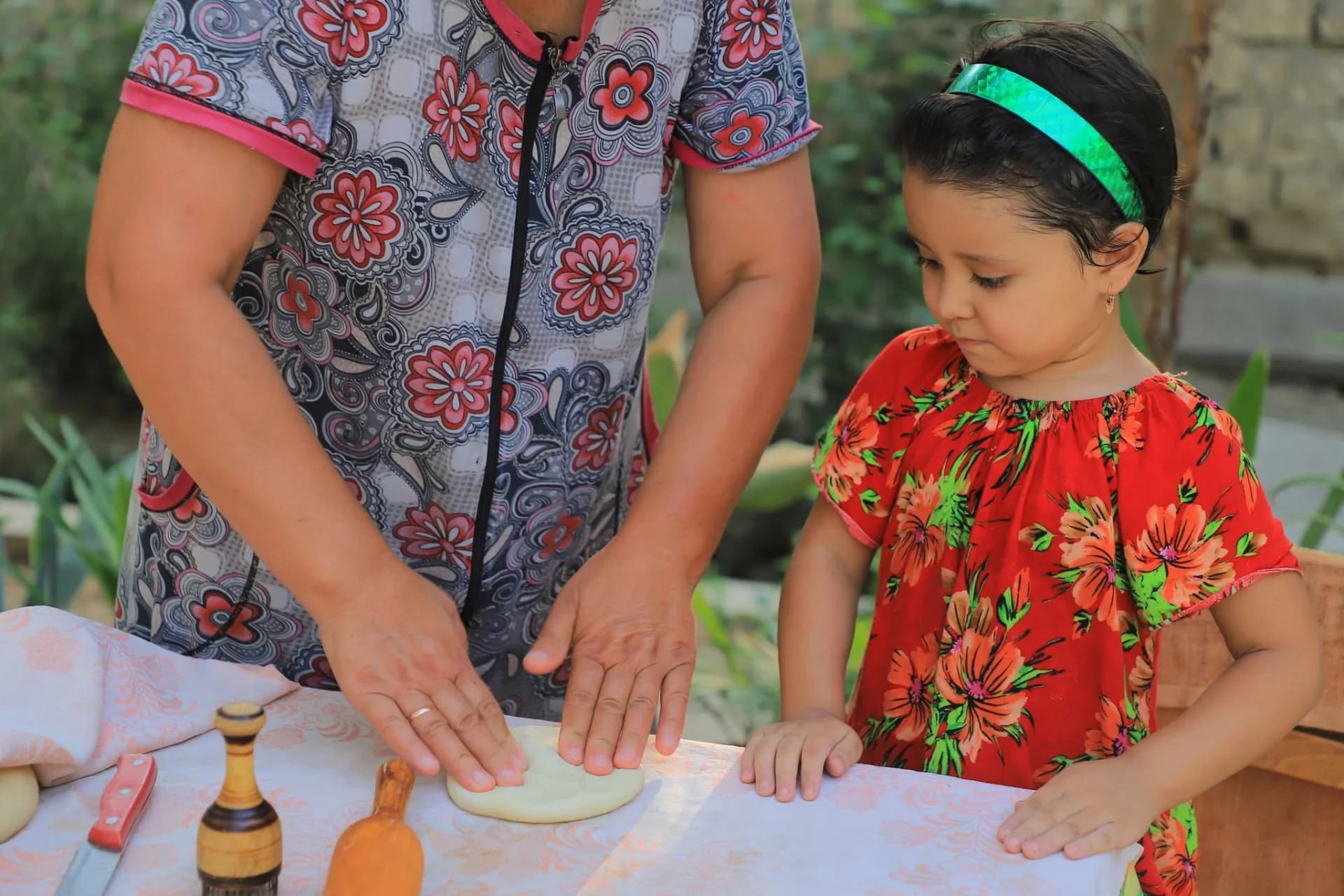Adult and child shaping dough together at a table