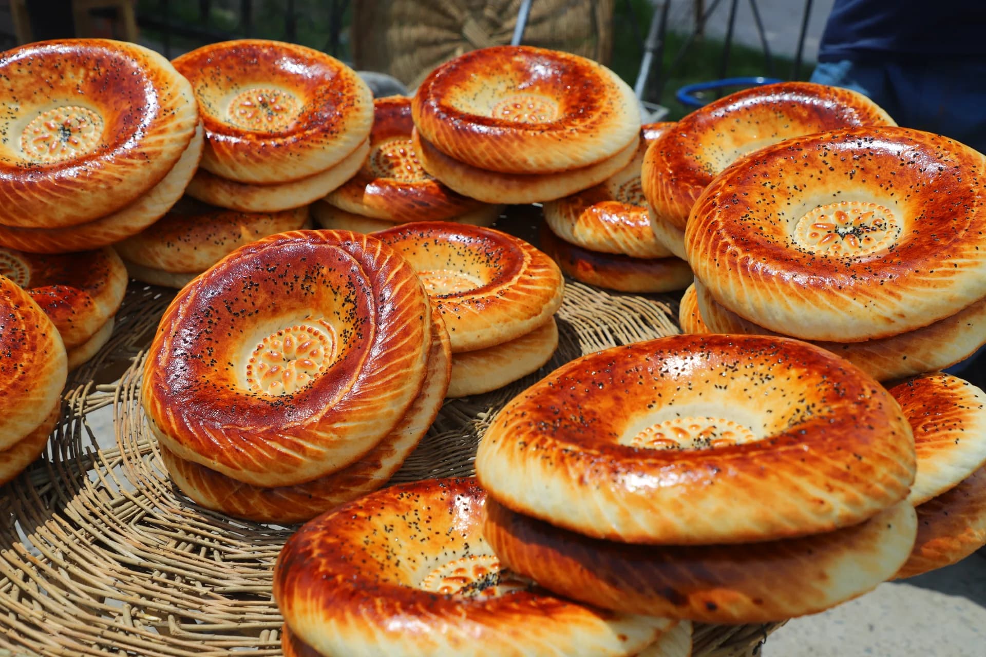 Freshly baked round flatbreads stacked on woven trays