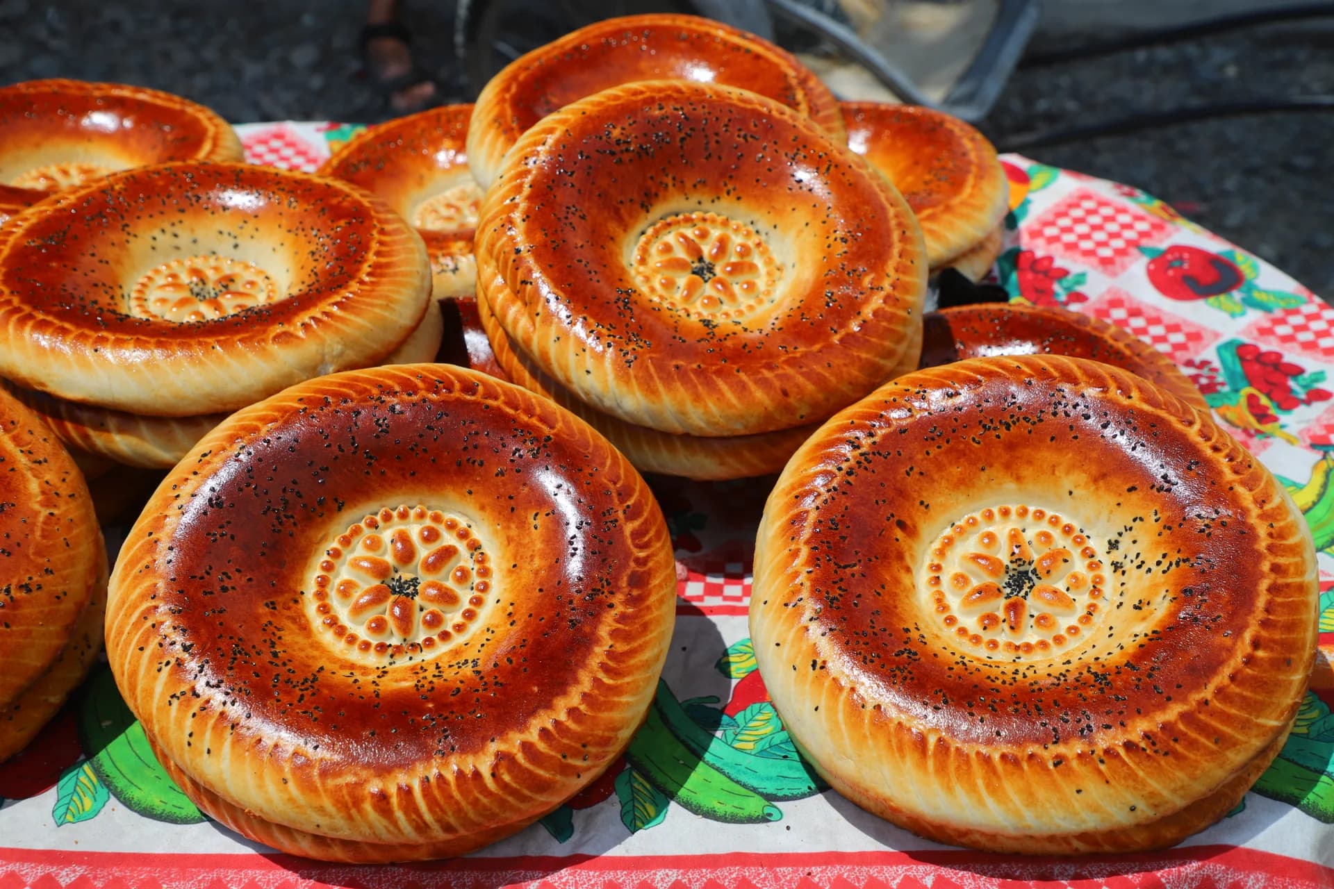 Freshly baked round flatbreads stacked on a patterned cloth