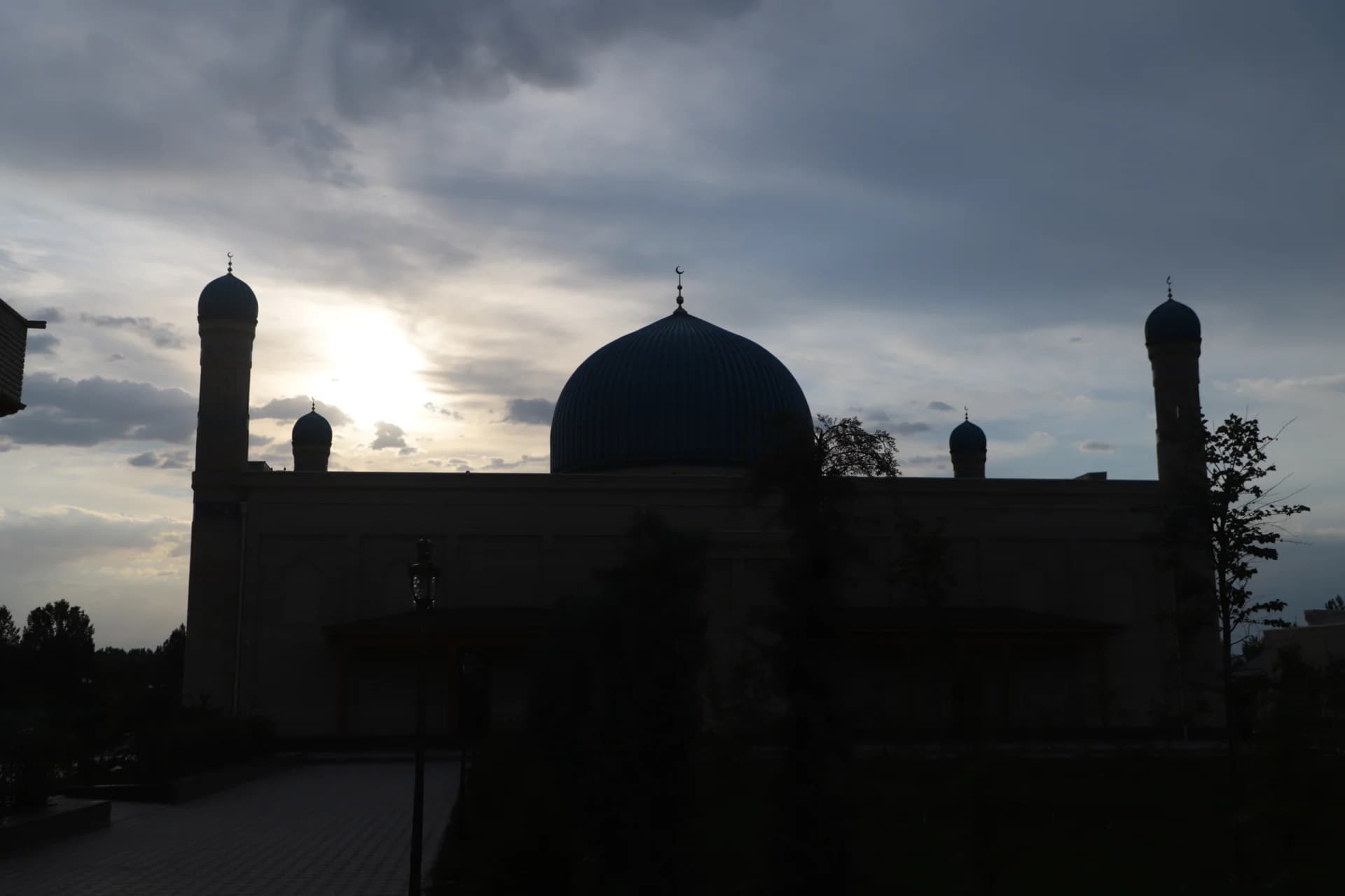 Mosque building silhouette under cloudy sky