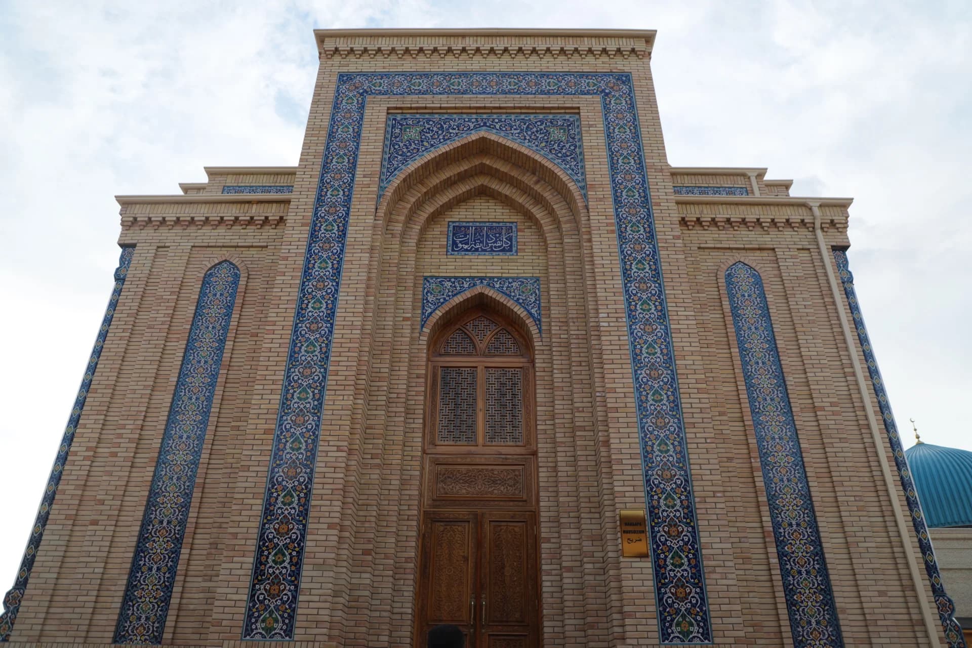 Detailed facade and entrance of a historic brick building with blue tilework