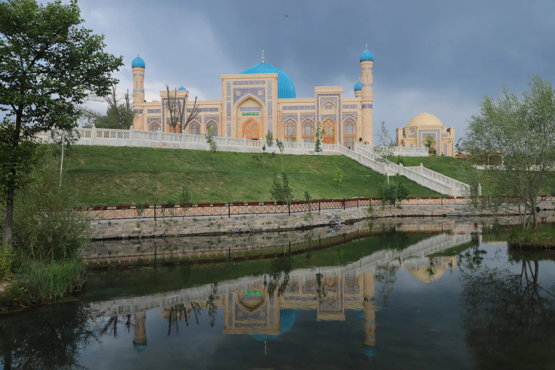 Mosque architecture with blue domes and minarets reflecting in water