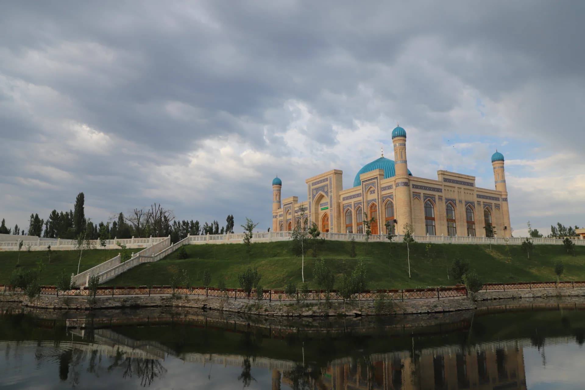 Traditional mosque architecture with blue domes and minarets near a body of water