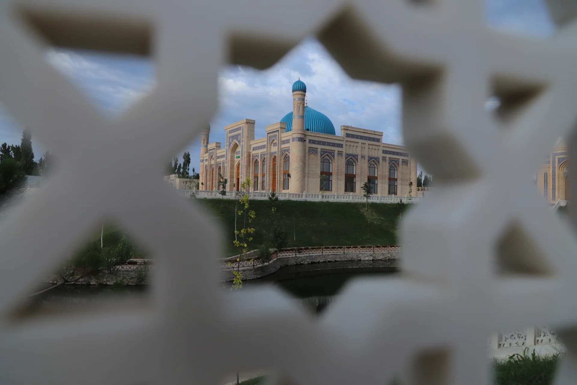 View of a mosque through an ornate geometric grille