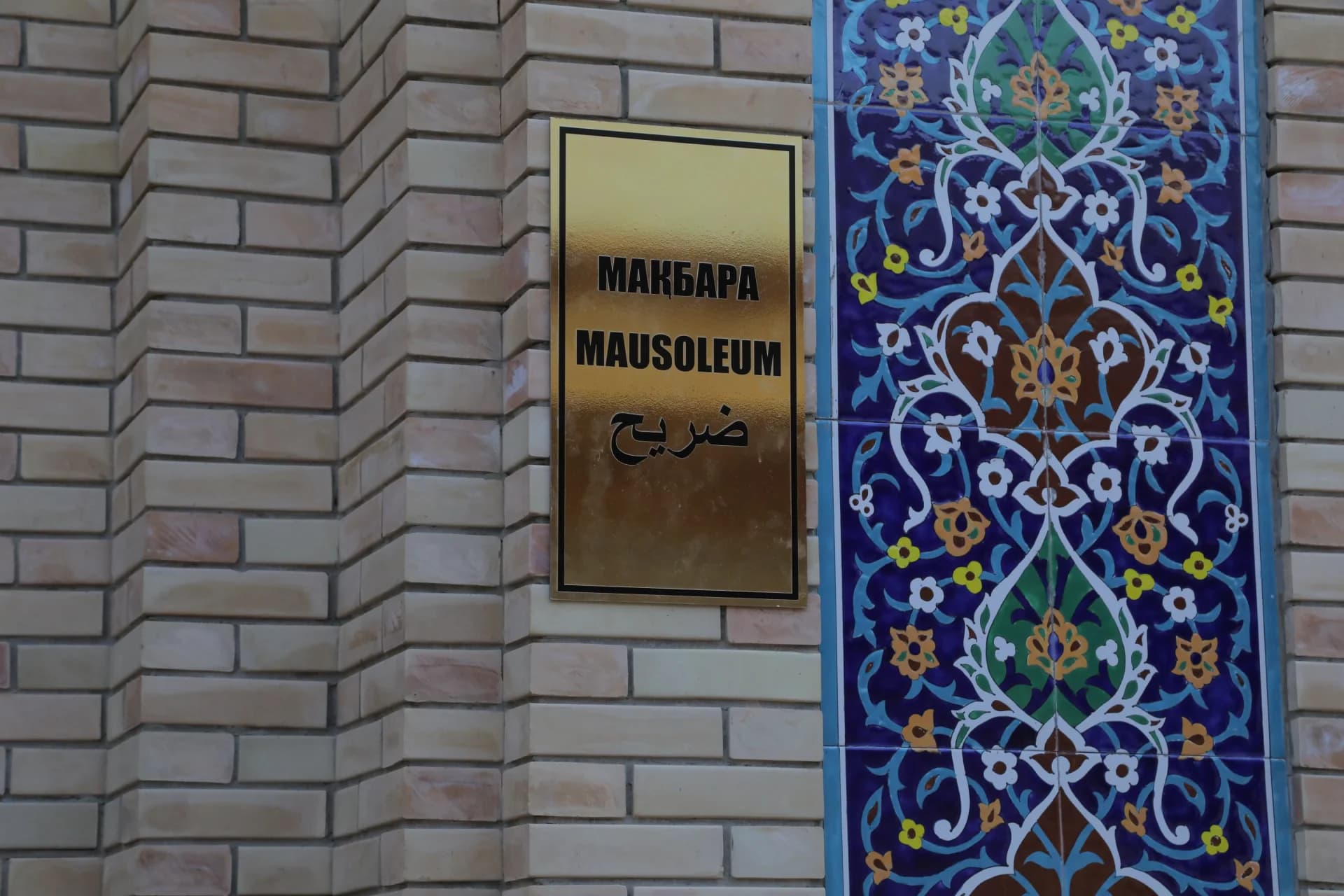 Mausoleum sign on a brick wall with decorative tiles
