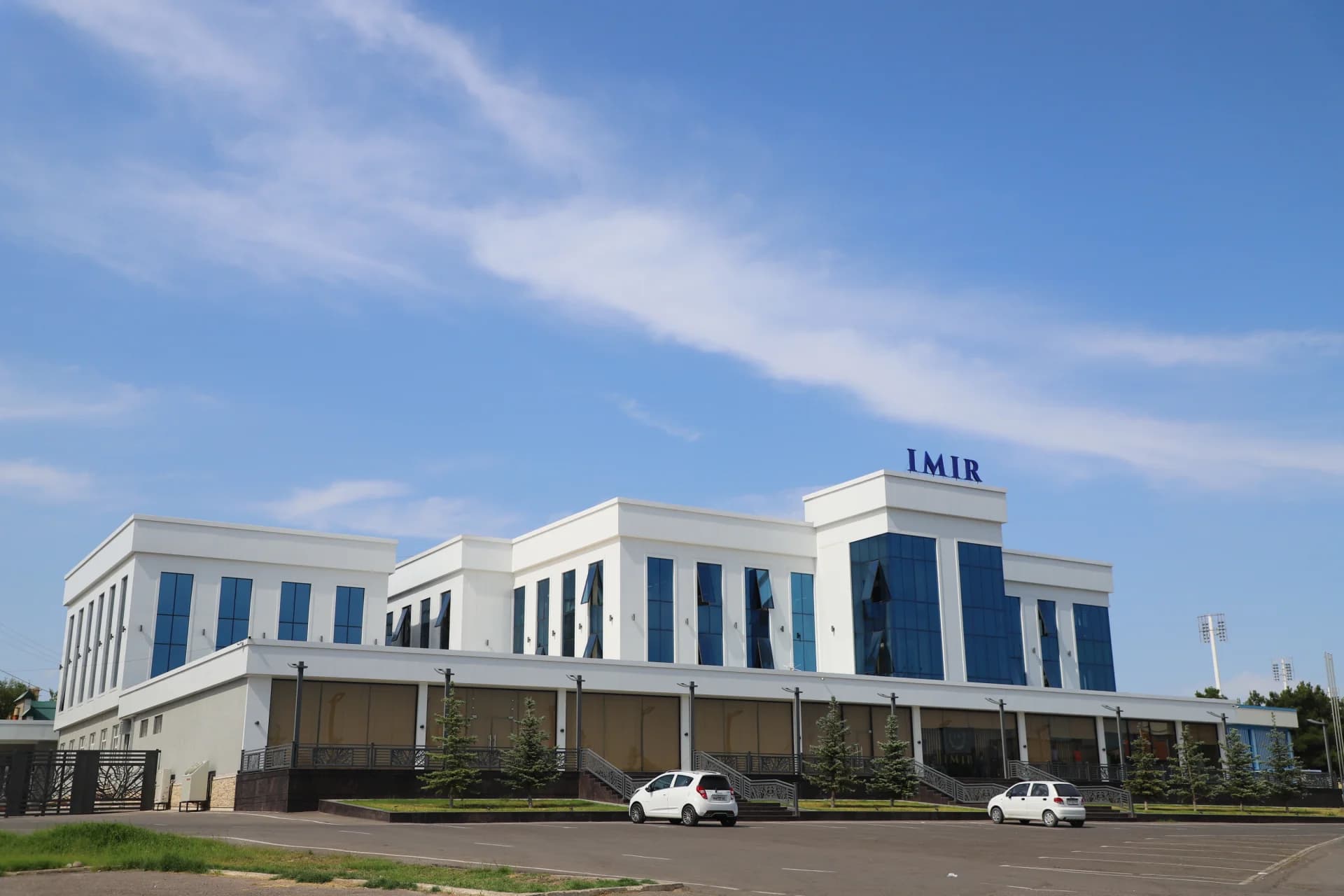 Modern white building with blue glass windows under blue sky