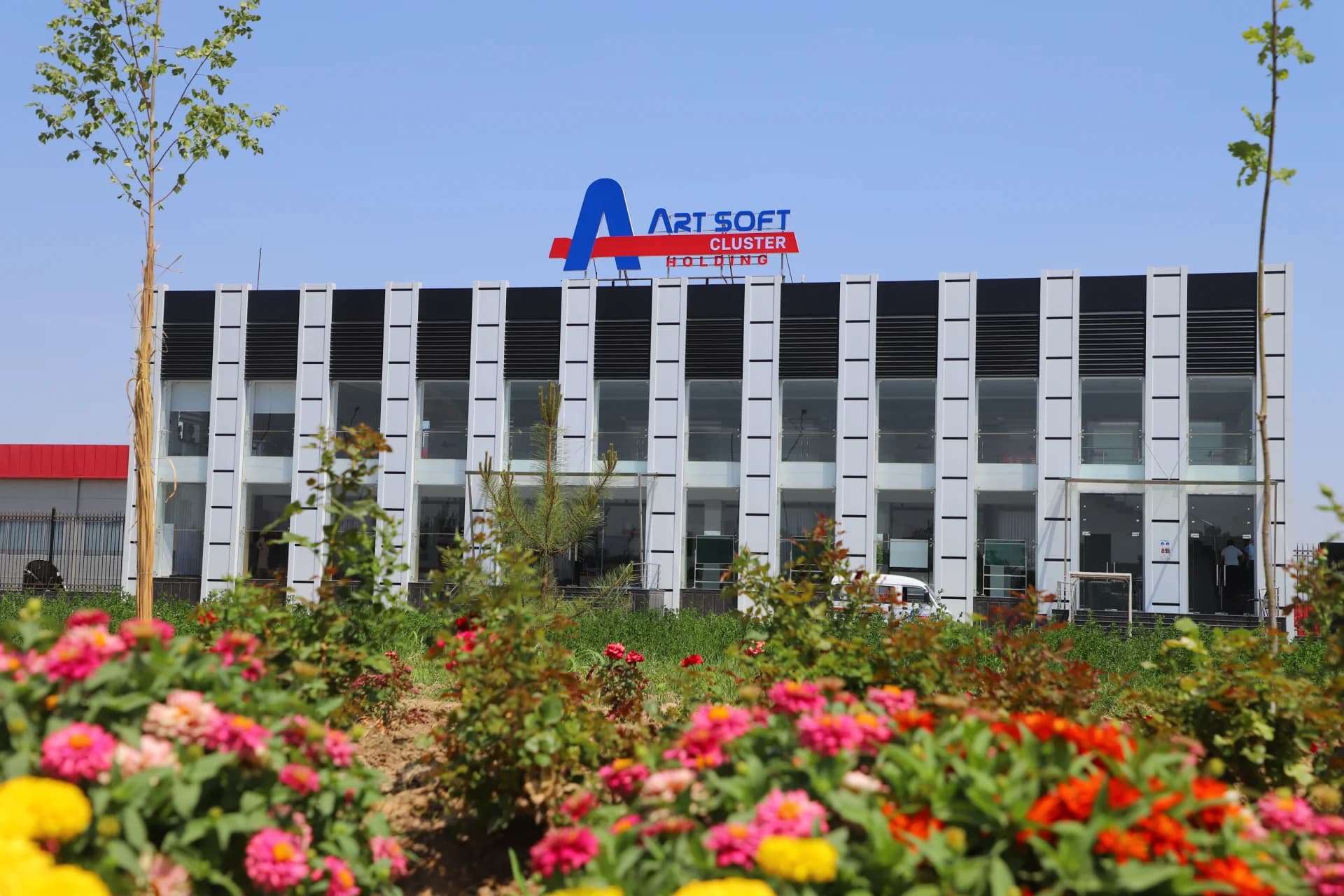 Modern building exterior with visible signage and landscaped garden foreground