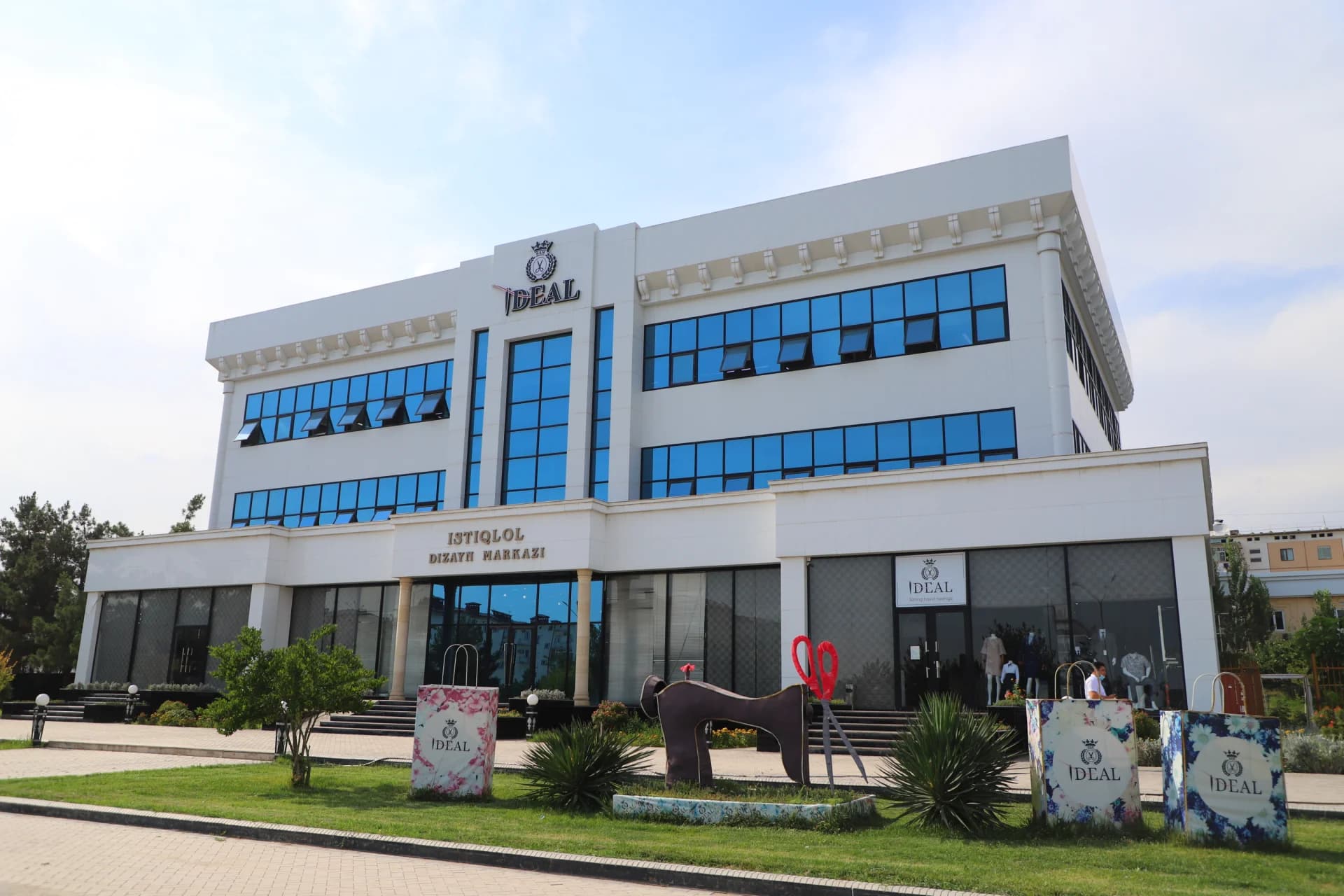 Modern white building exterior with blue windows and signage