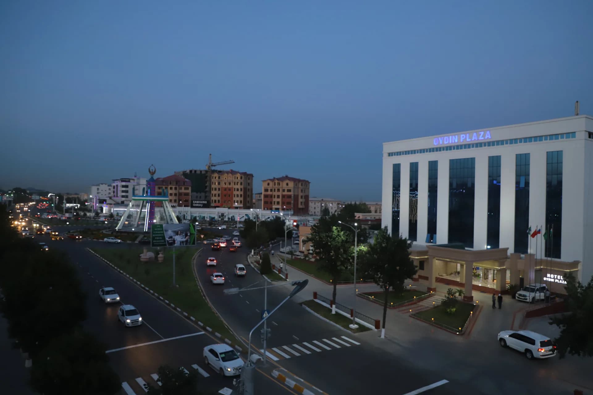 City street scene with cars and modern buildings at dusk