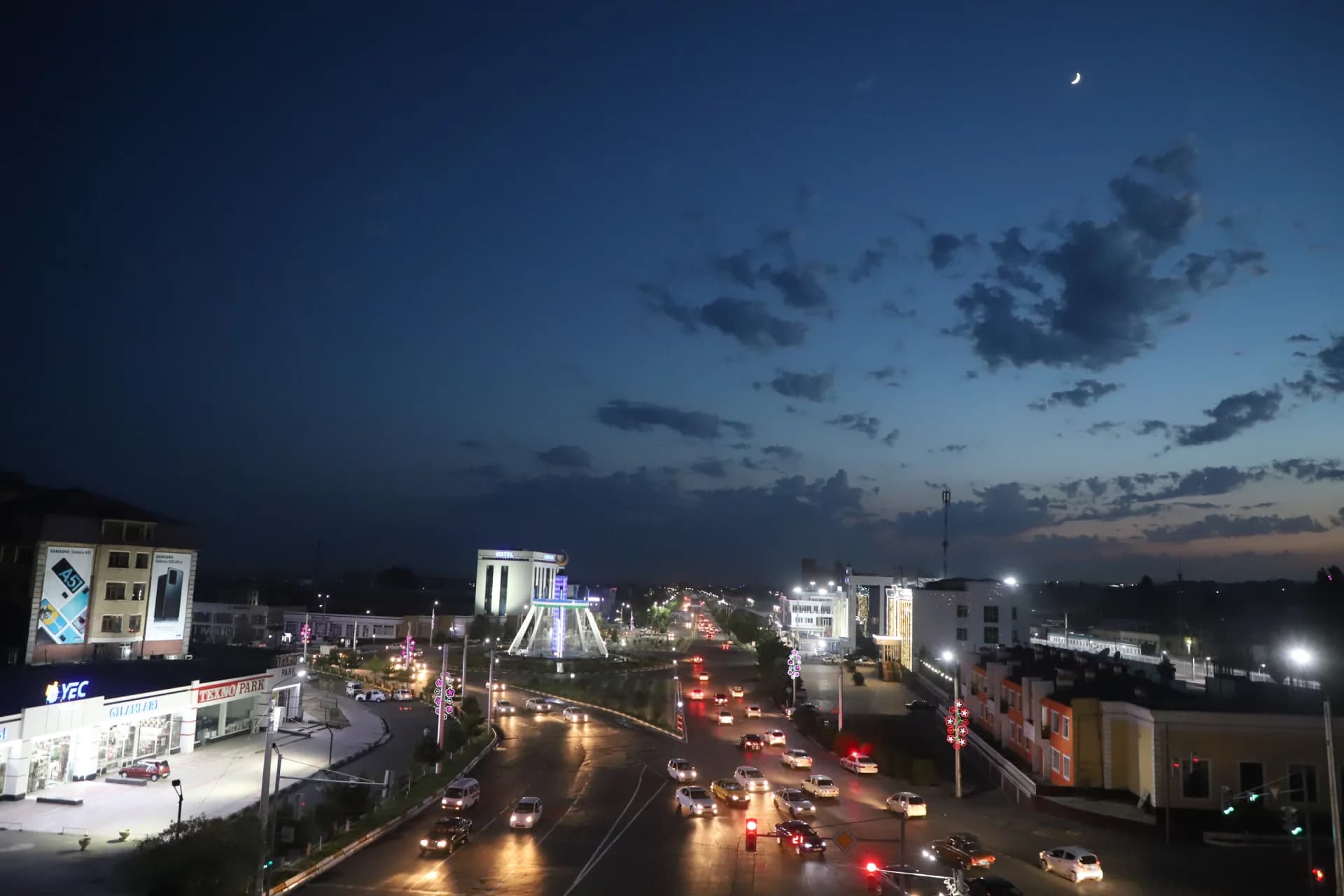 City street view at night with illuminated buildings and traffic