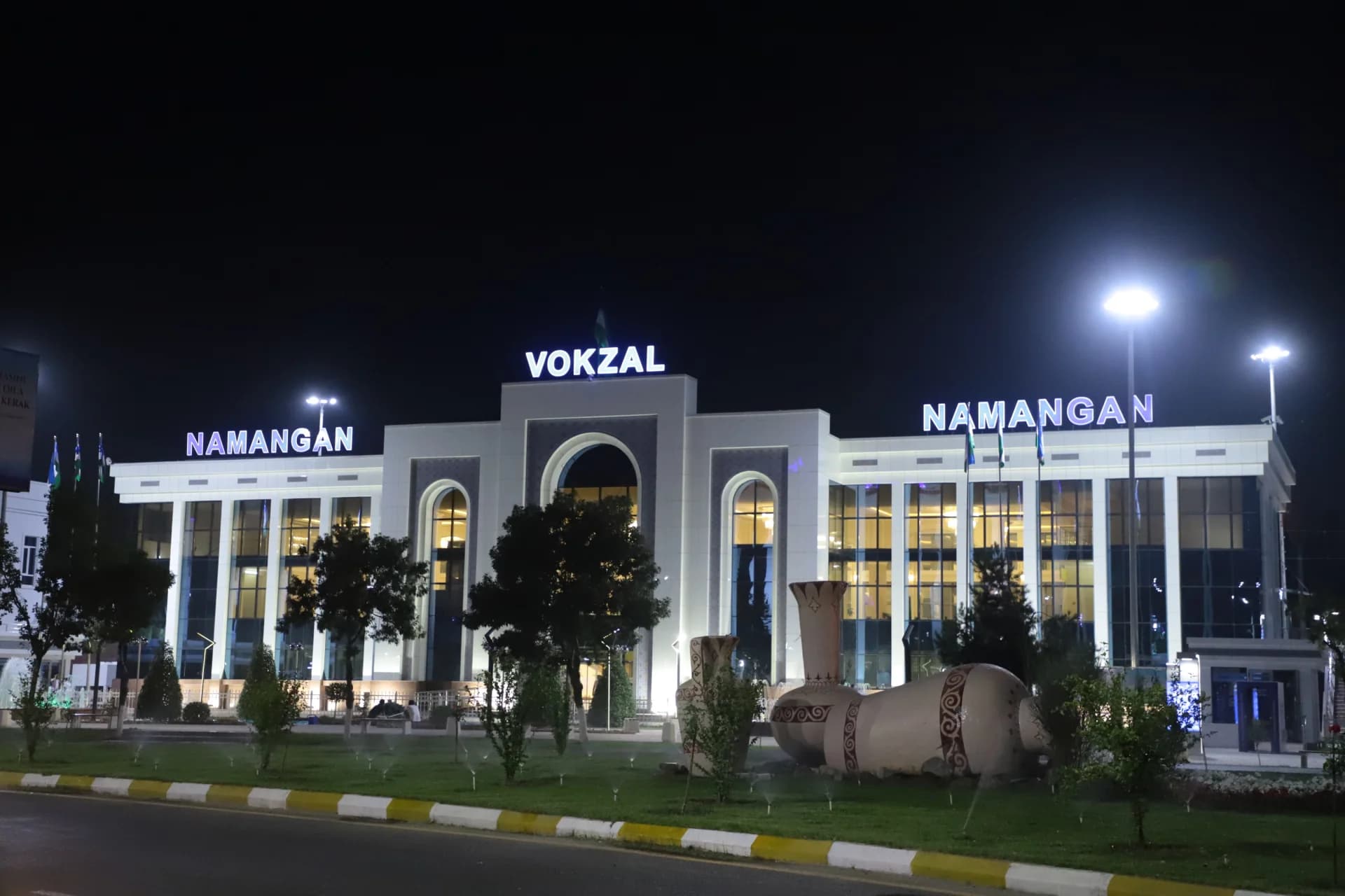 Illuminated building exterior at night with decorative ceramic structures in the foreground