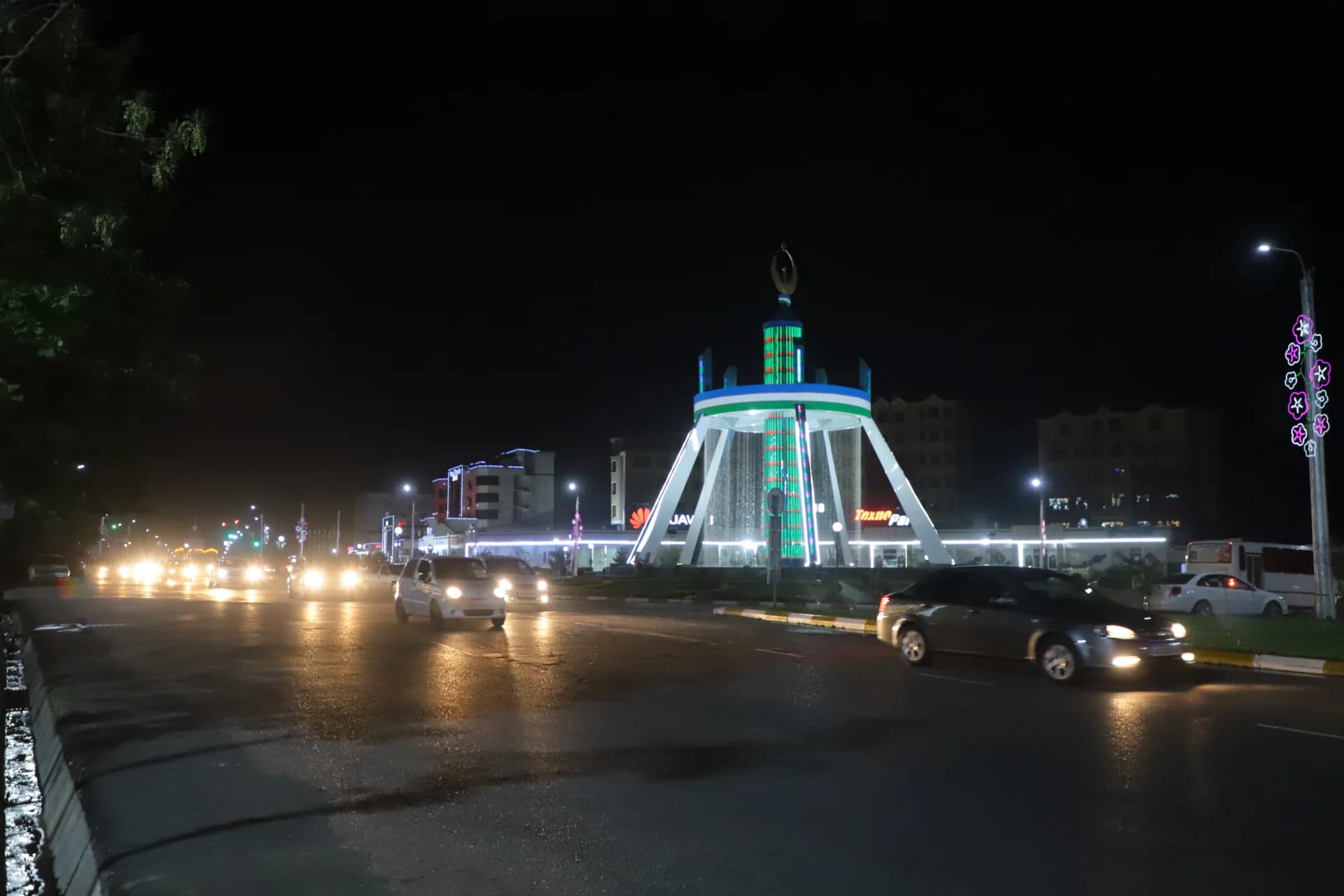 Night city street traffic near illuminated monument