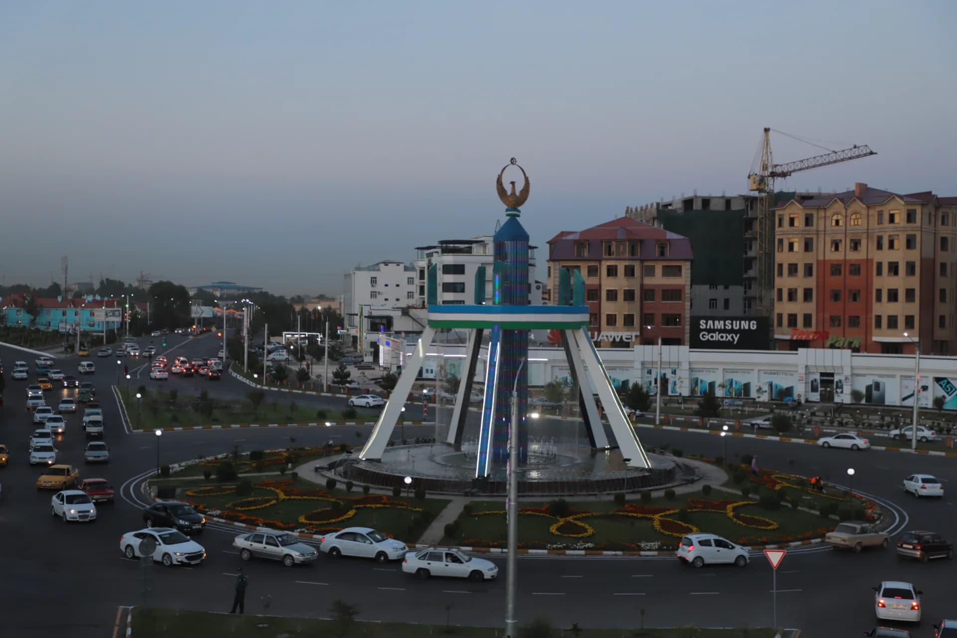 City roundabout with large central monument and vehicle traffic