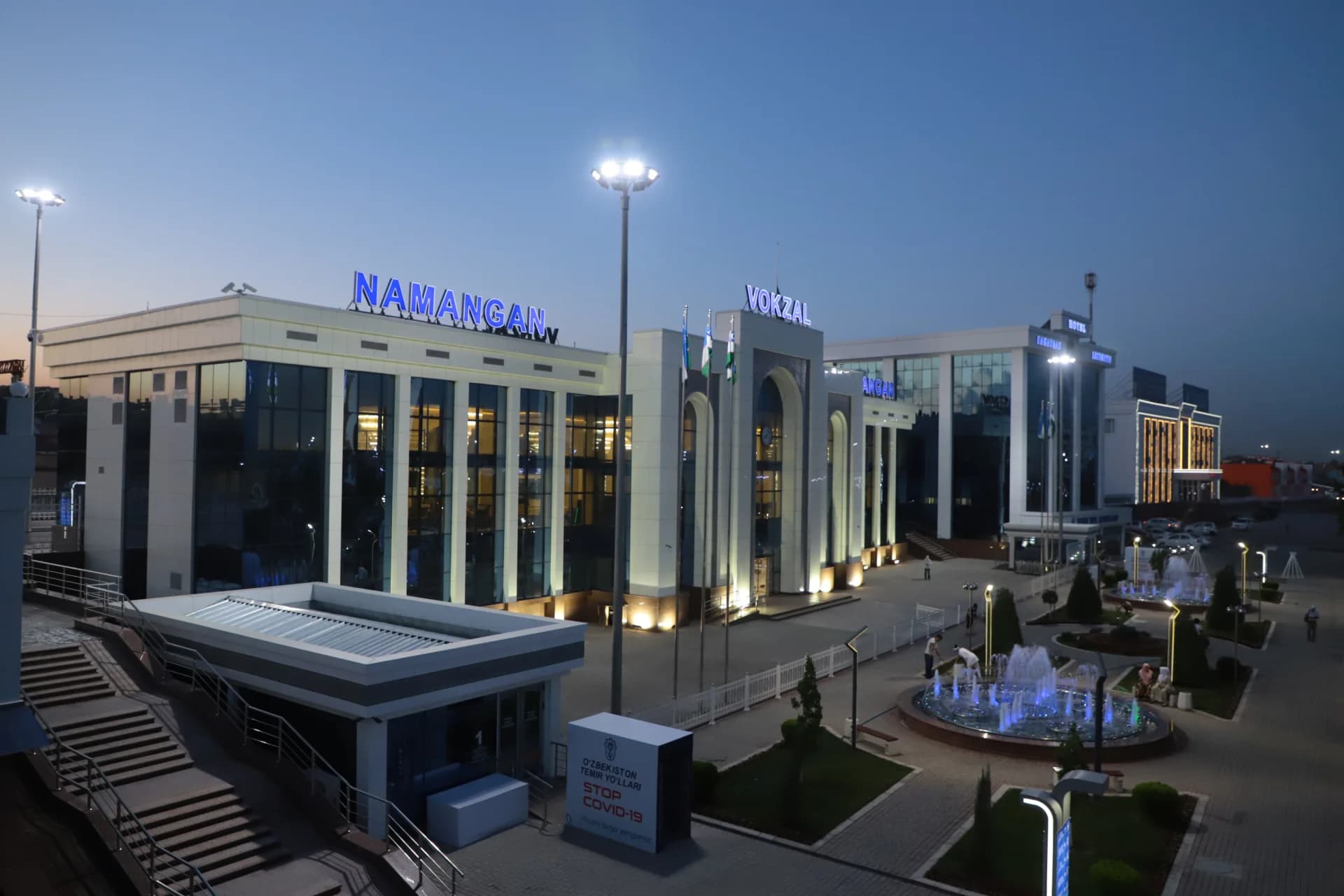 Exterior view of a illuminated modern building with glowing signs at dusk