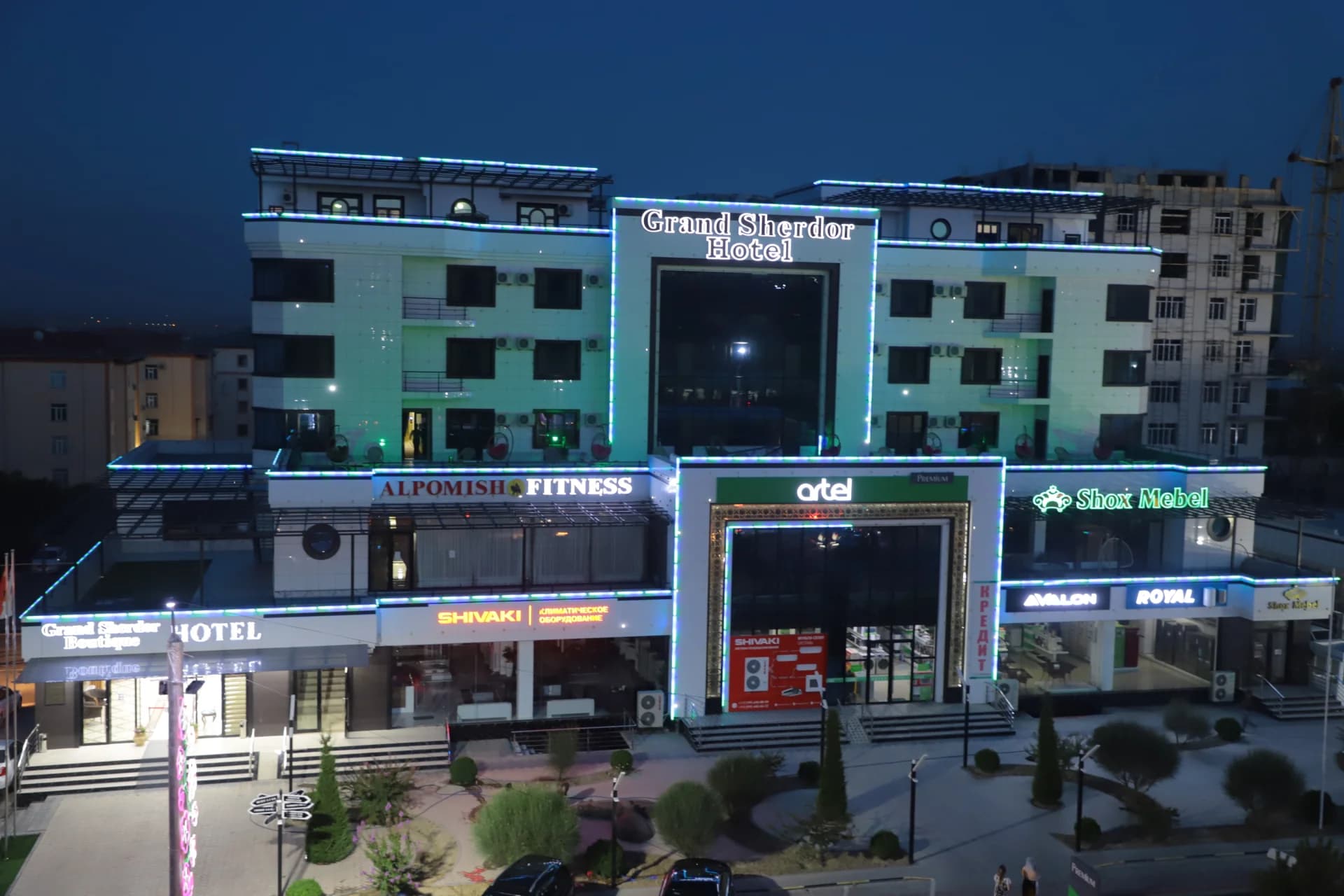 Illuminated hotel and commercial building exterior at night
