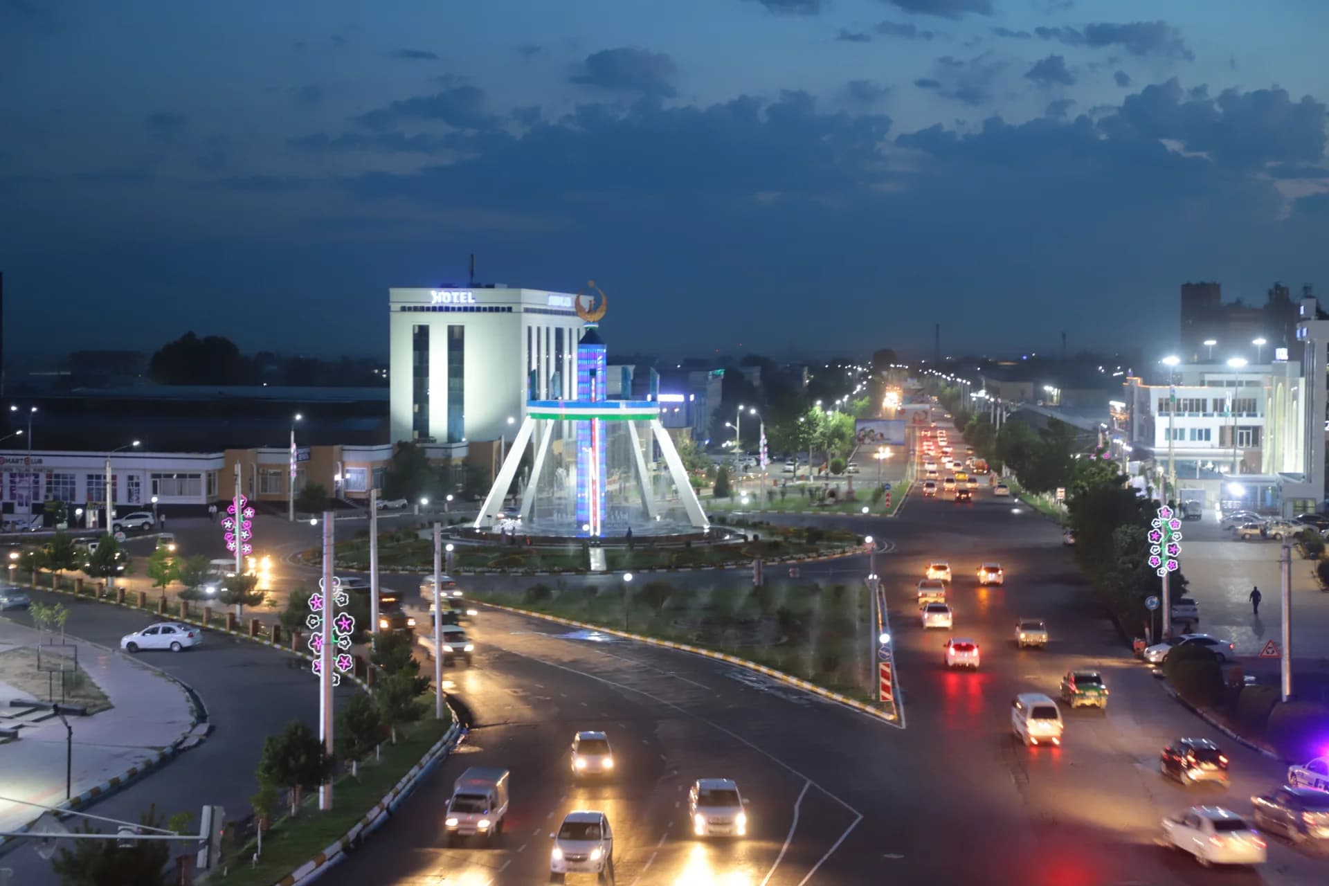 City street intersection with heavy evening traffic and illuminated buildings