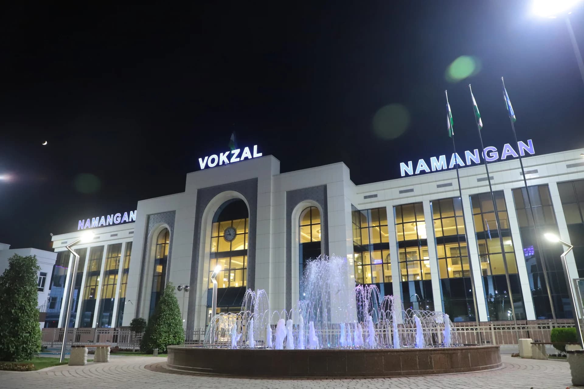 Illuminated building exterior at night with a fountain in front