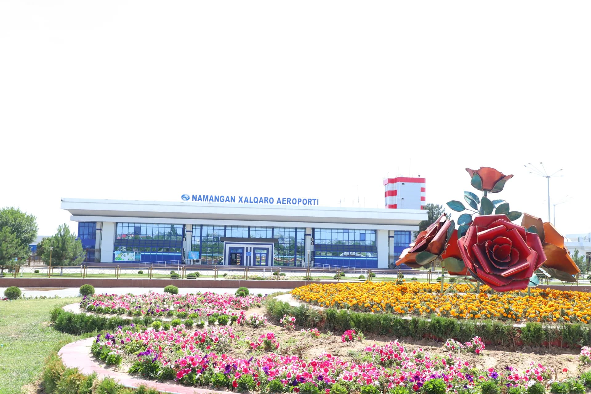 Airport building exterior view with flower gardens