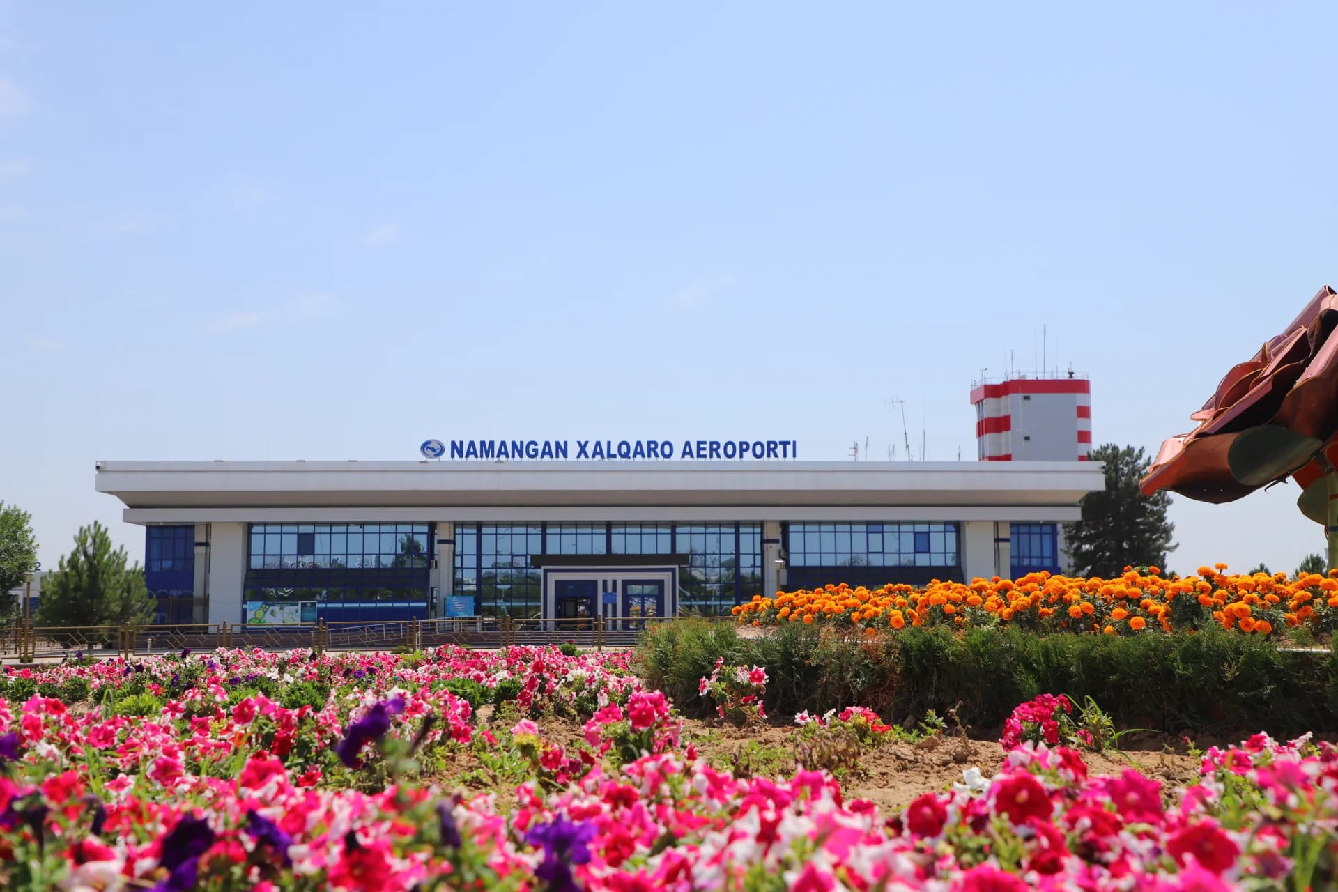 Airport building exterior with flower beds in the foreground