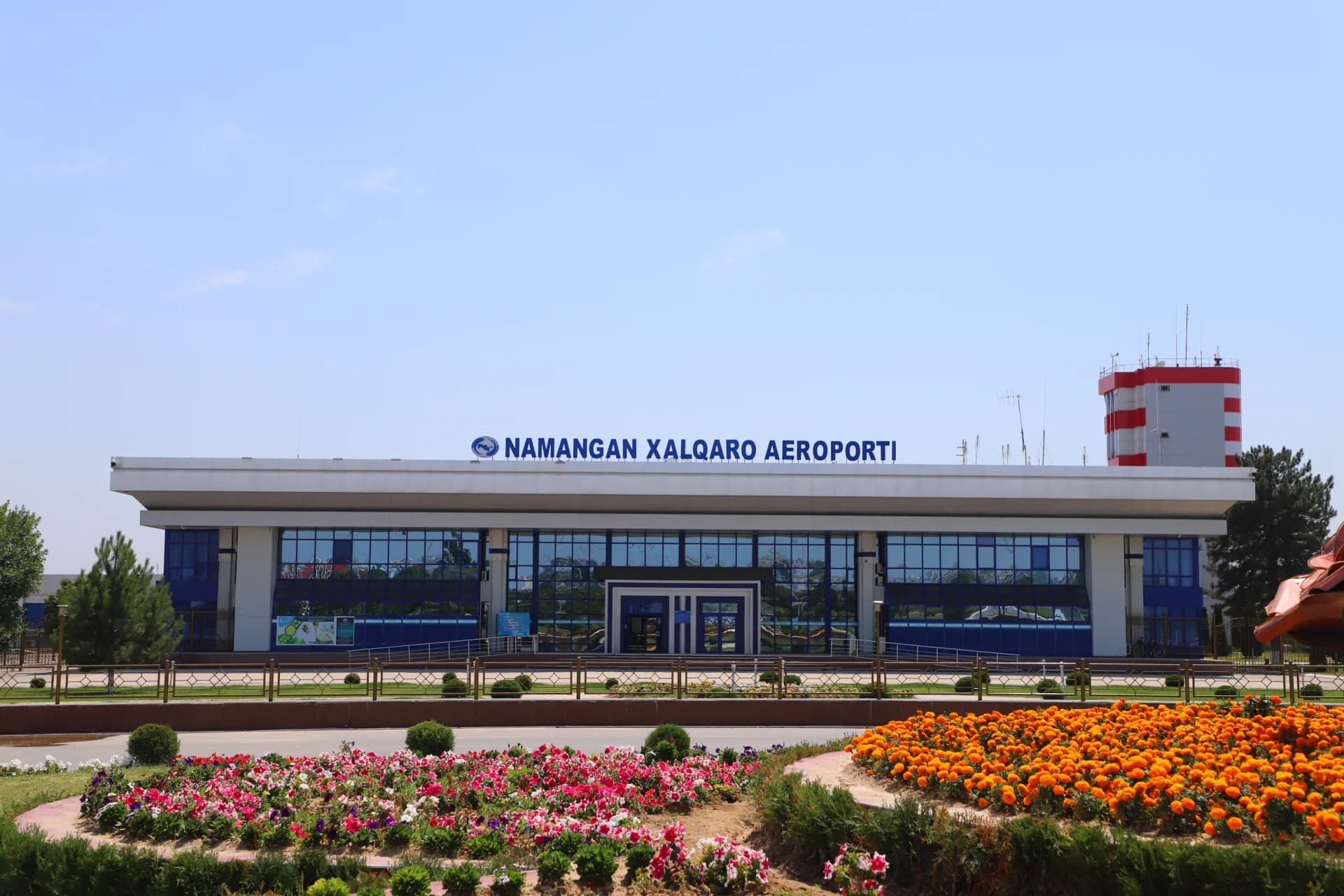 Exterior view of airport terminal building with blue glass facade and signage