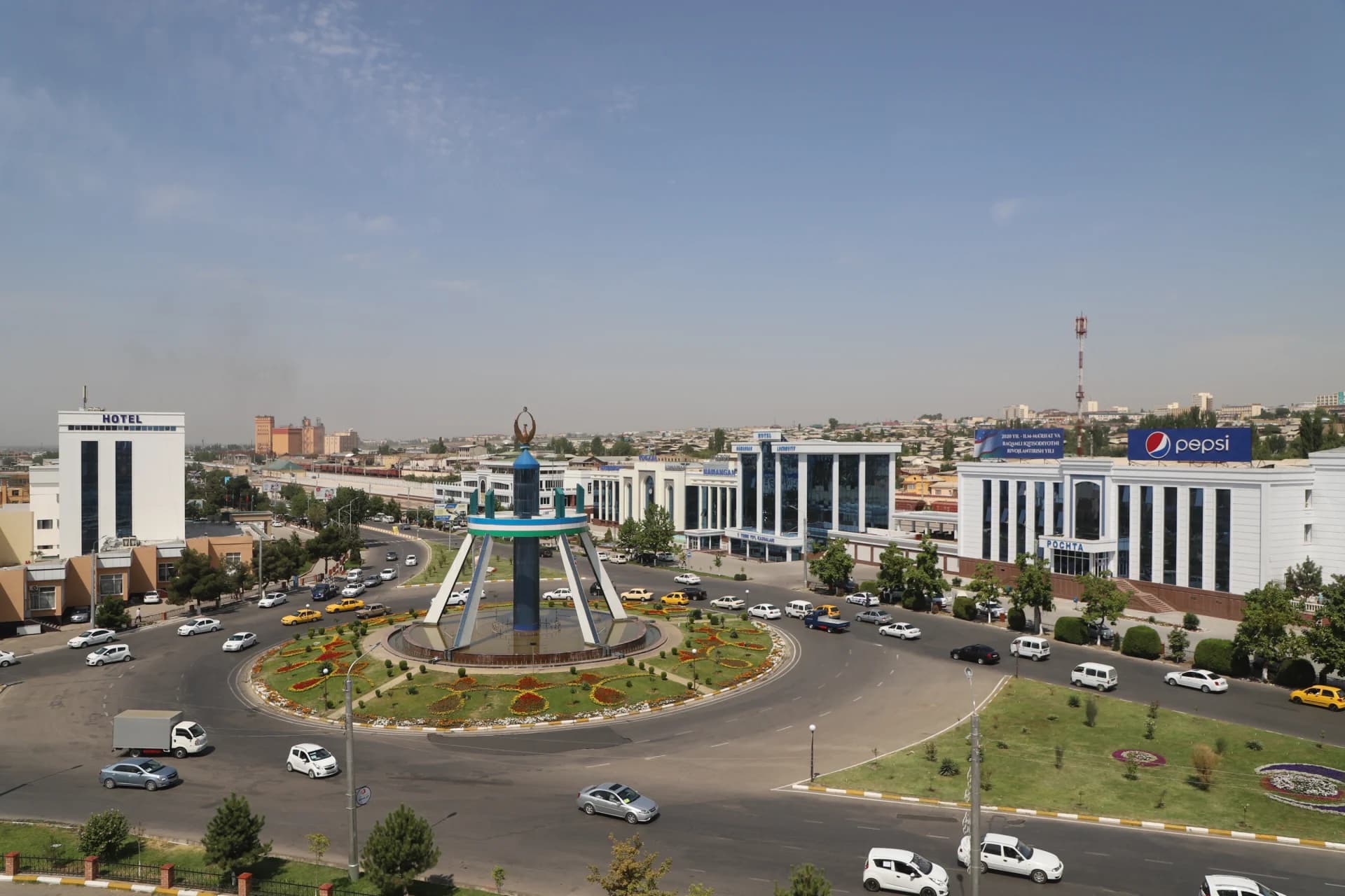 City traffic circle with central monument and surrounding buildings