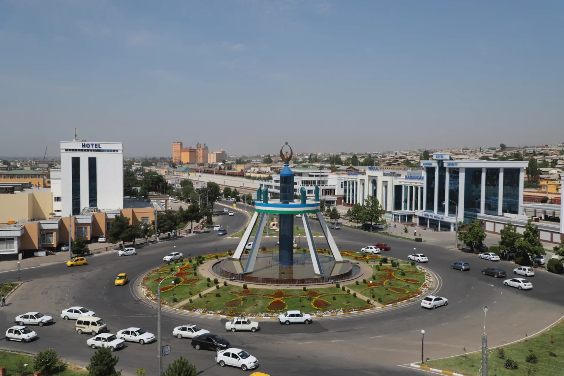 High-angle view of a city traffic circle with a central monument