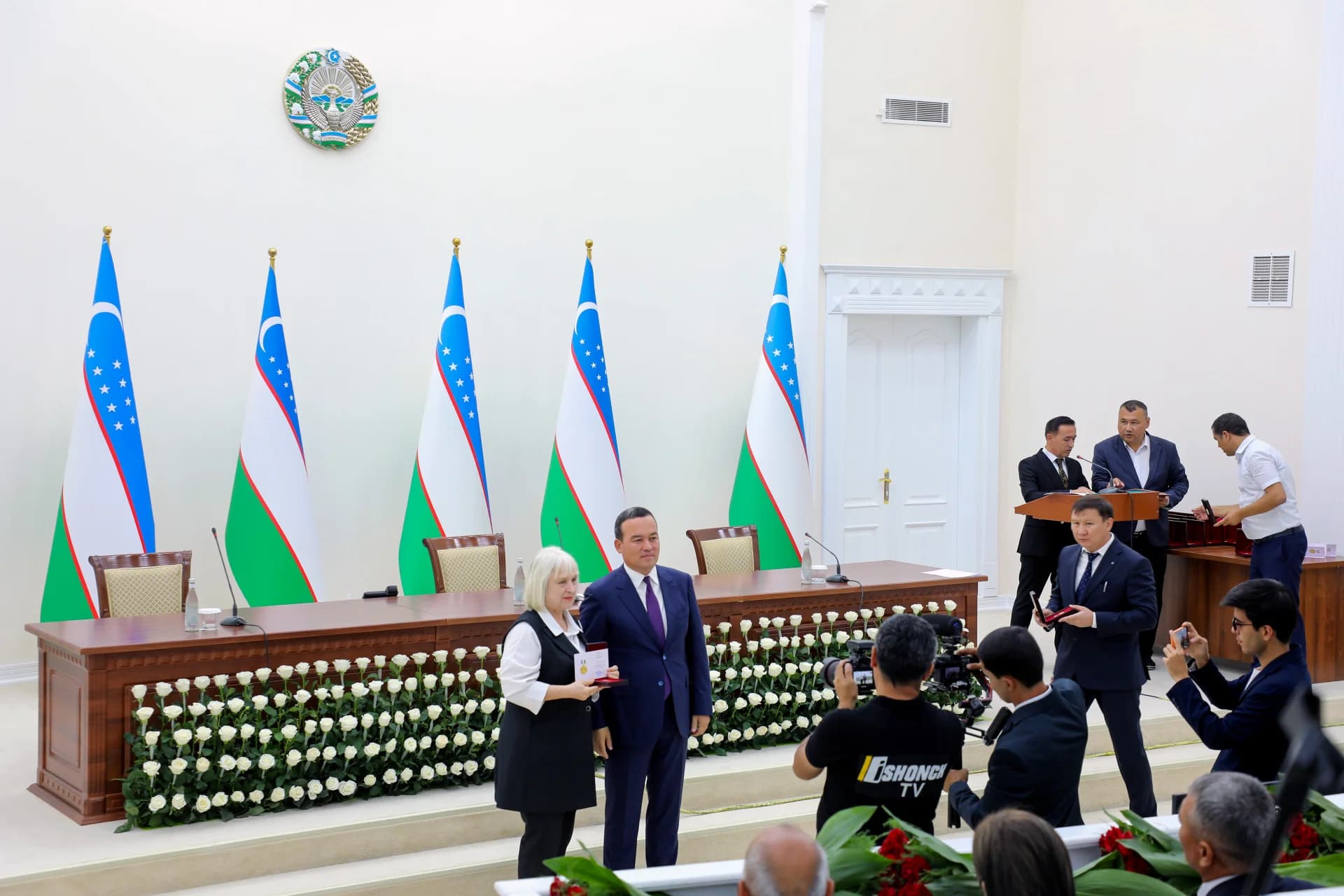 Official award ceremony in a hall with flags