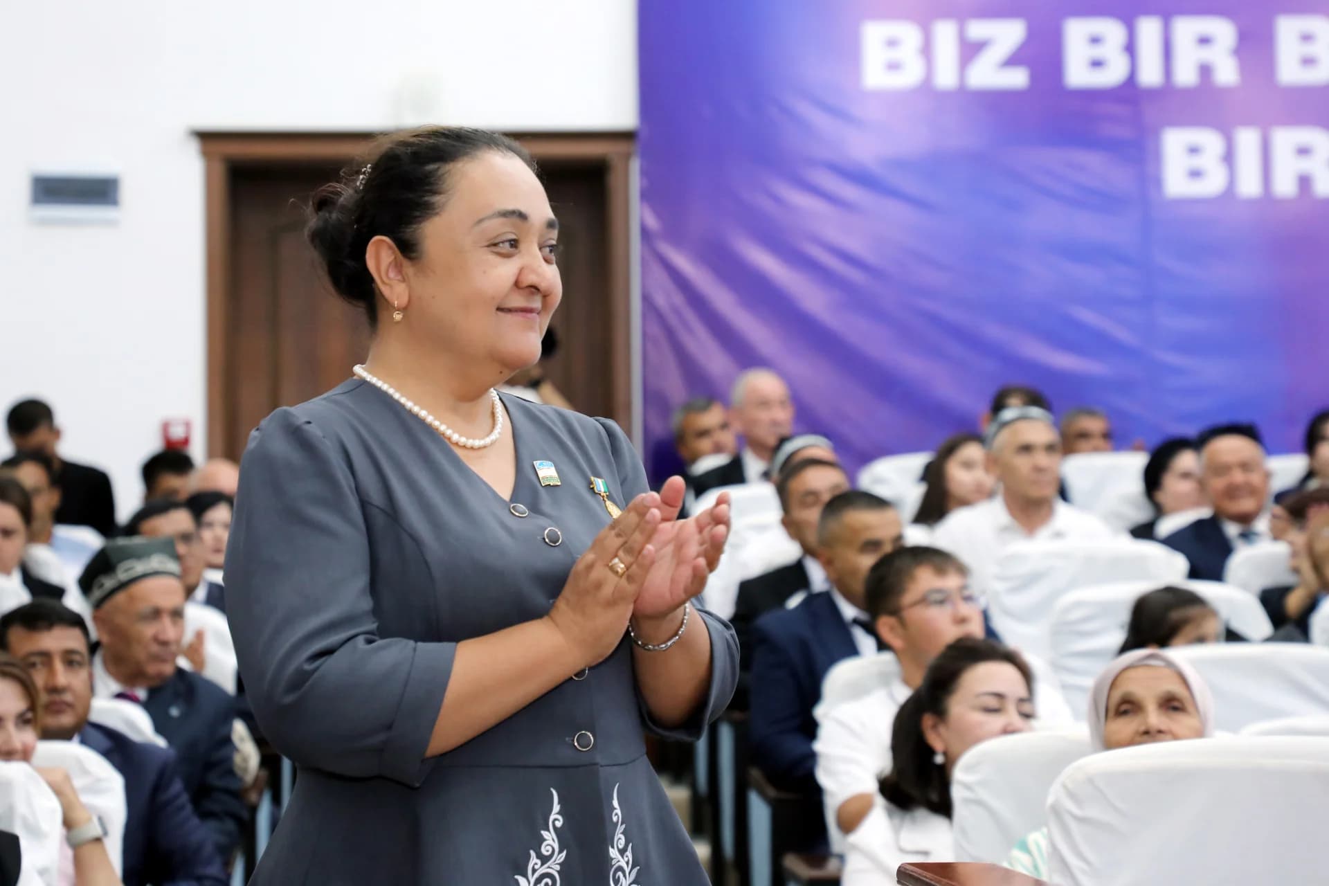 Woman clapping during an indoor public gathering