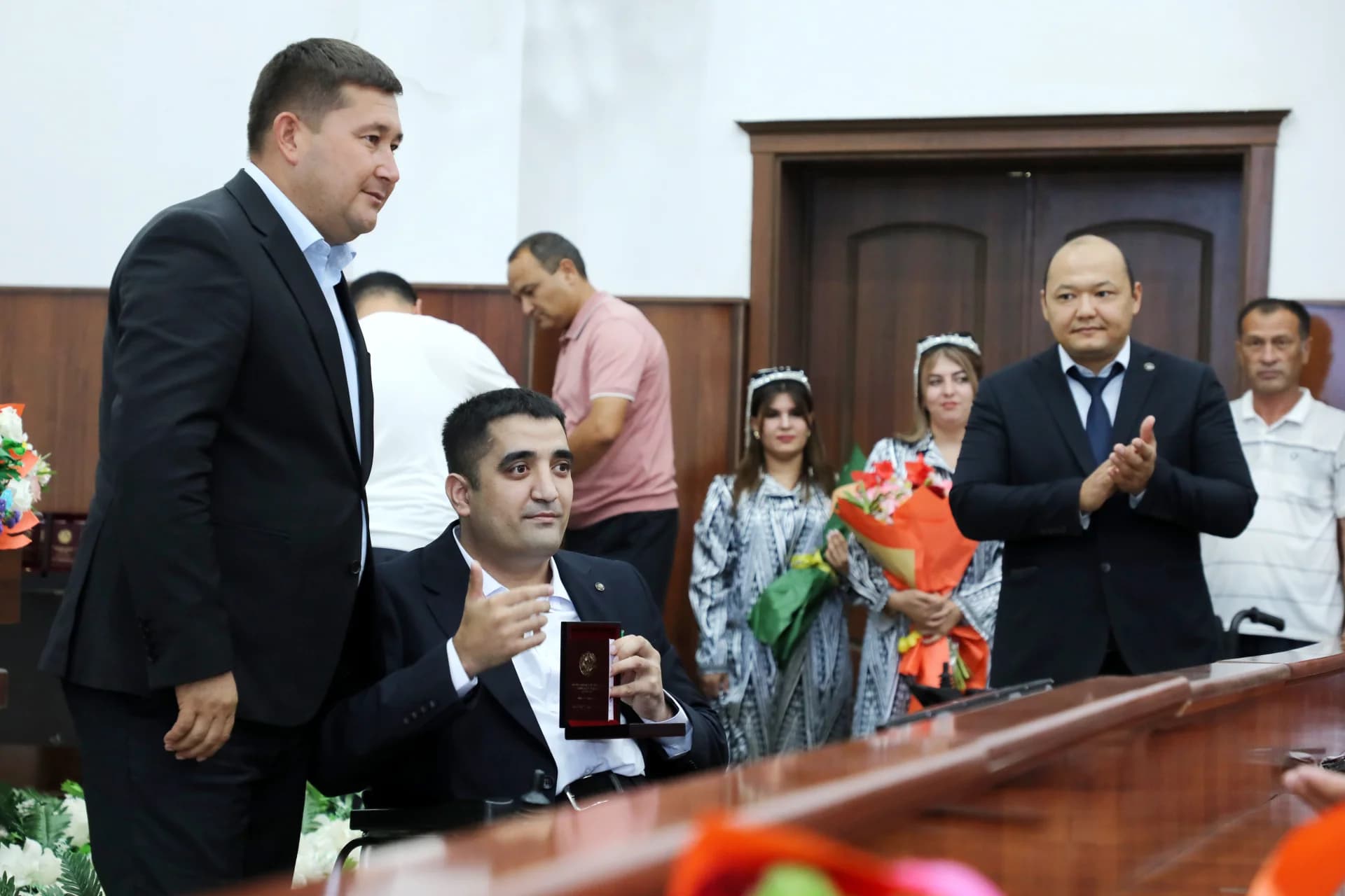 People gathered indoors for a presentation and ceremony