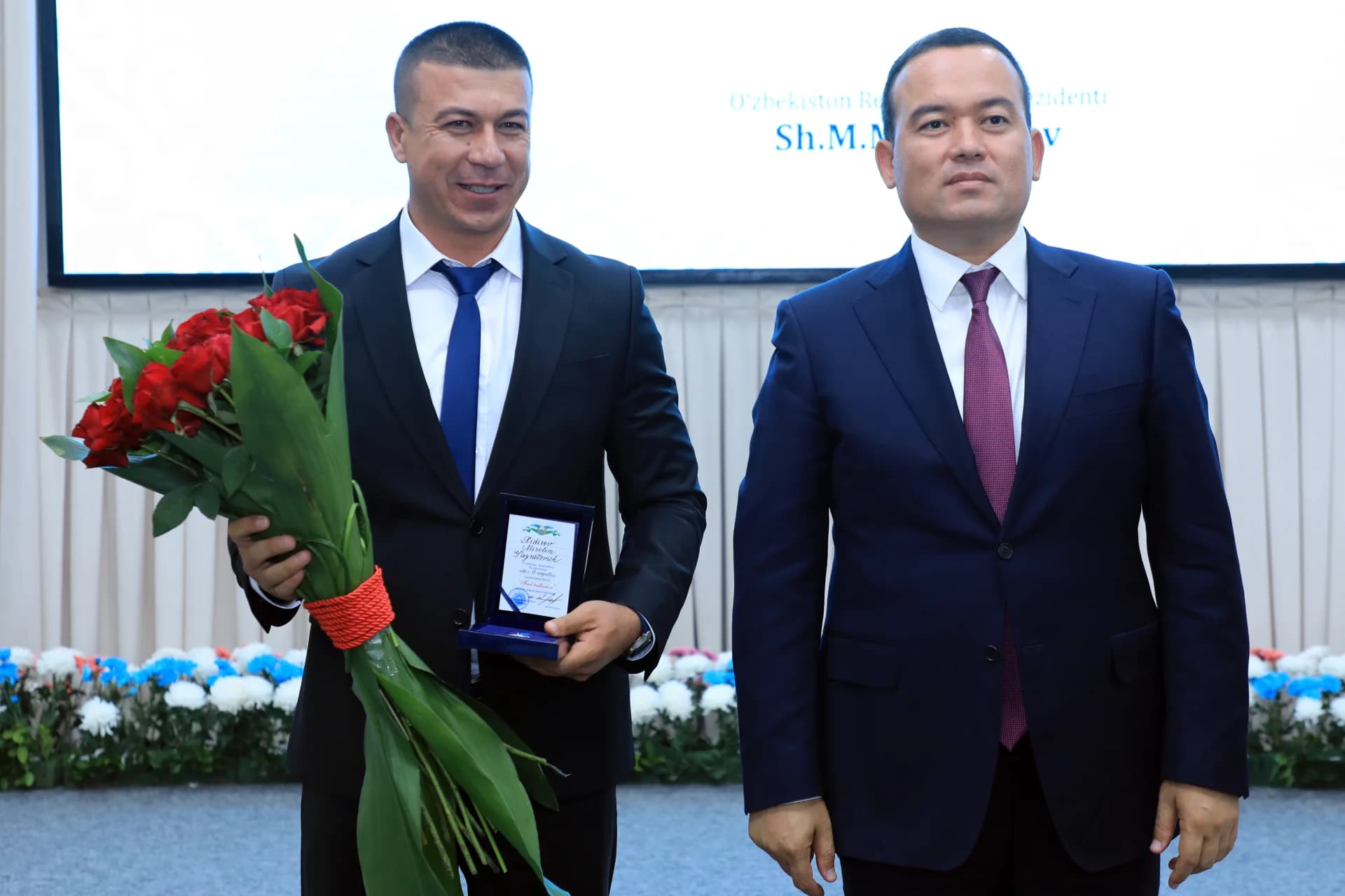 Two men in suits posing together indoors