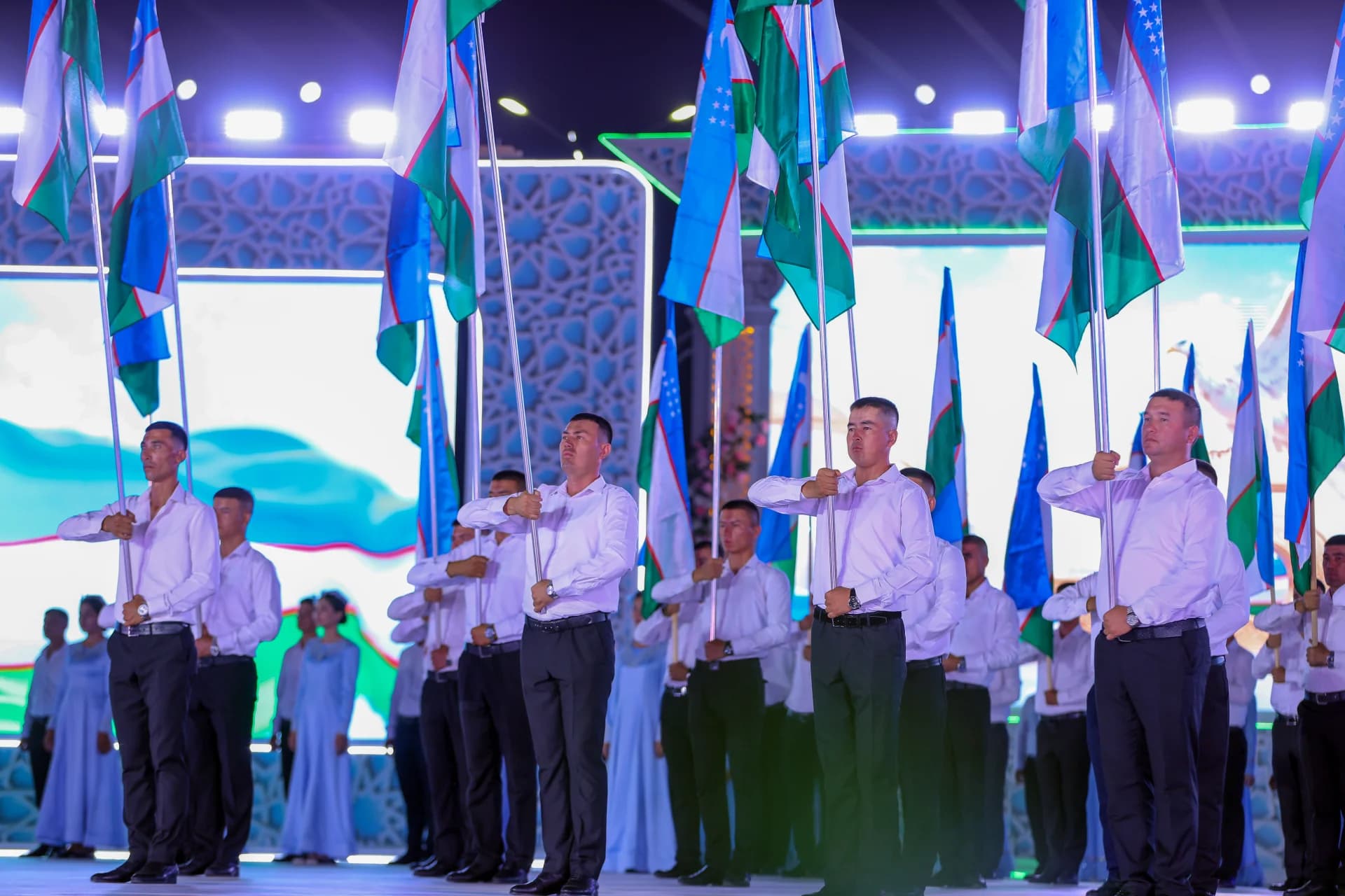 People holding flags during event on stage