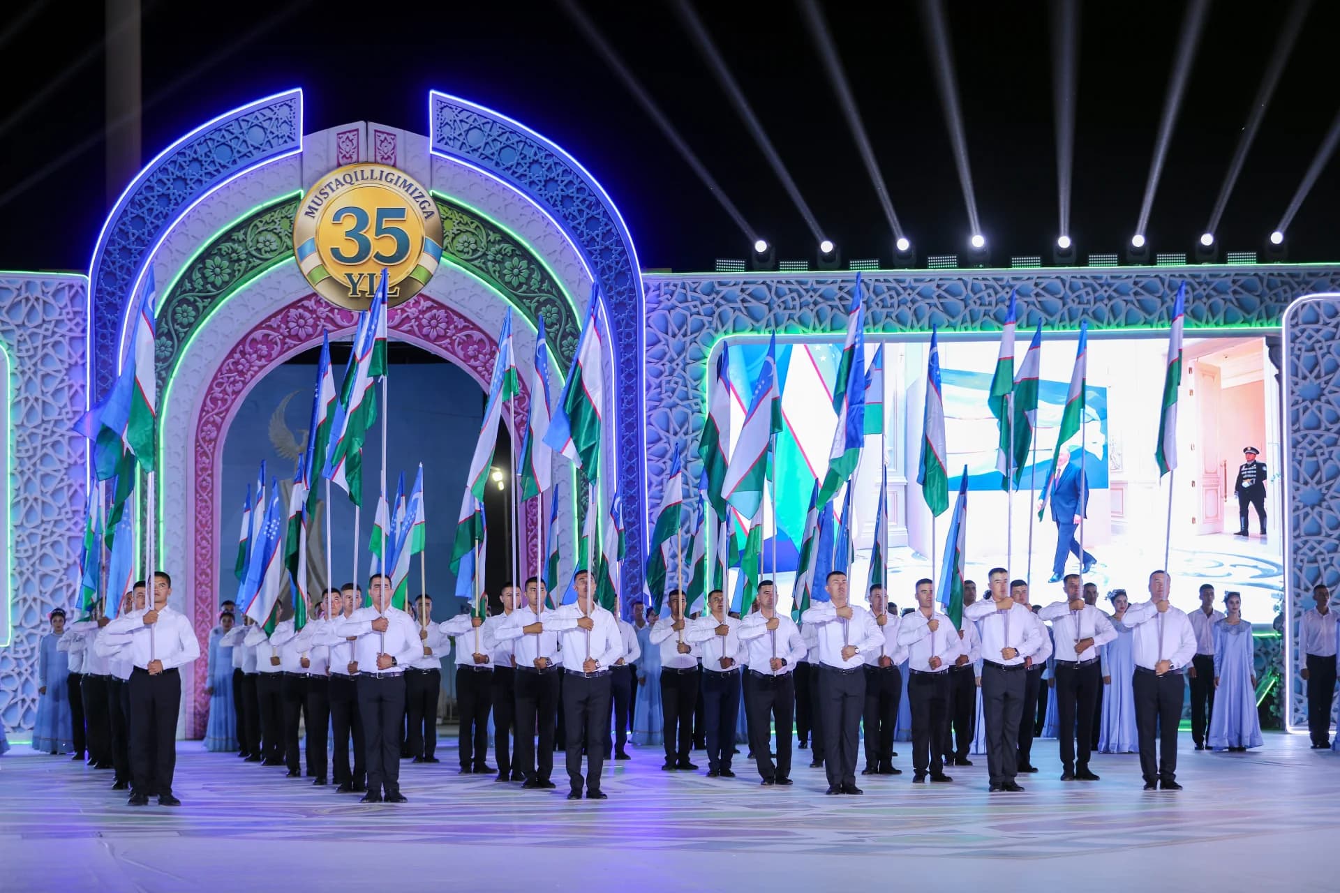 People holding flags during an event on stage