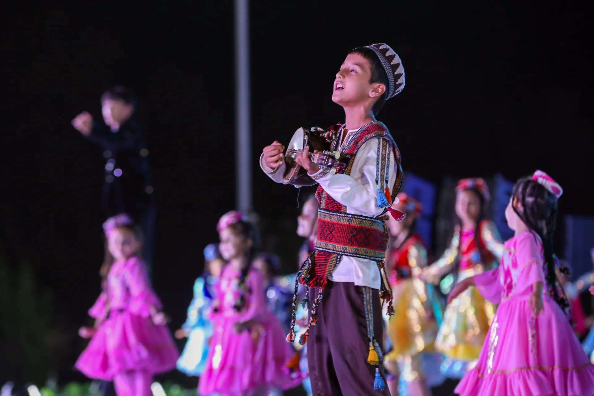 Young boy performing with traditional instrument during cultural event