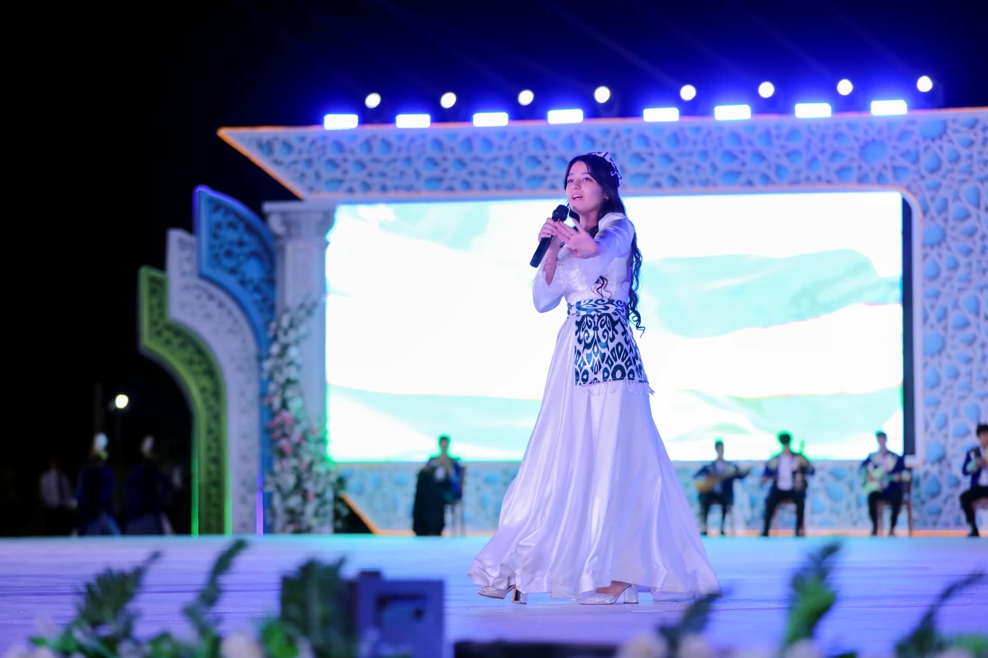 Young woman singing on stage with microphone