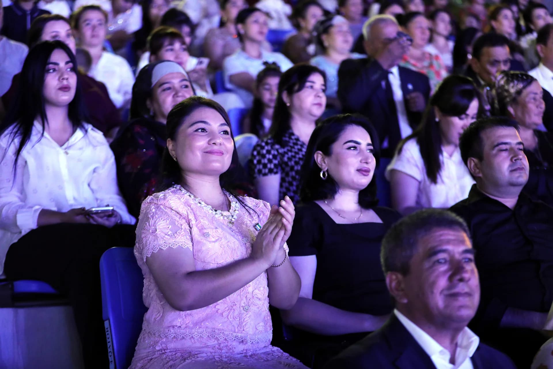 People seated in an audience clapping