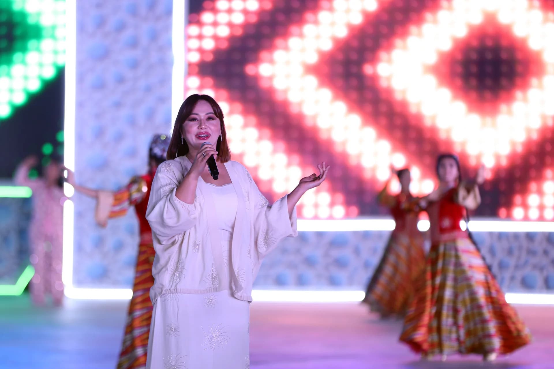 Woman singing into a microphone on stage