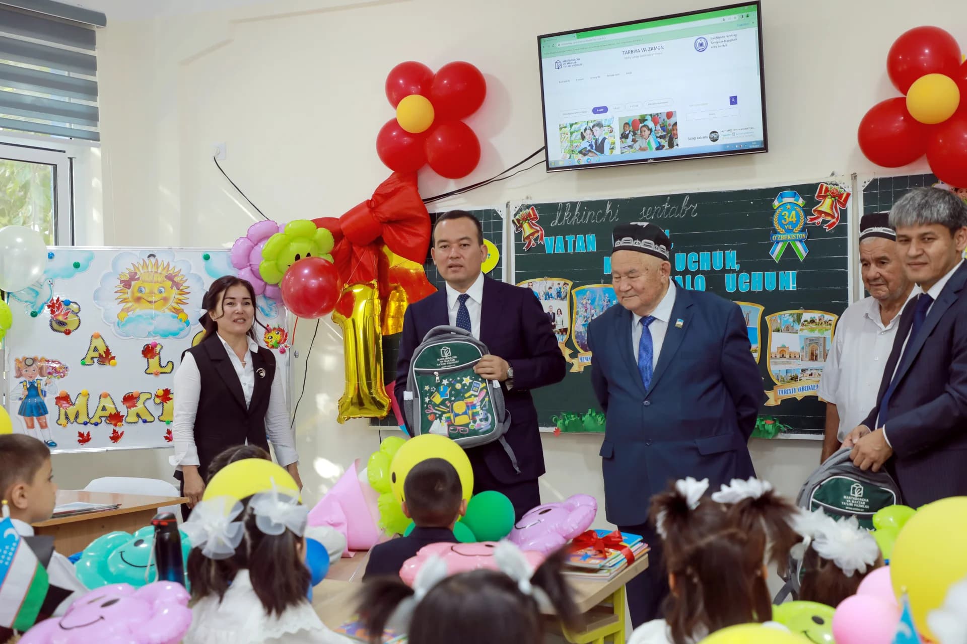 Взрослые и дети собрались в украшенном классе.