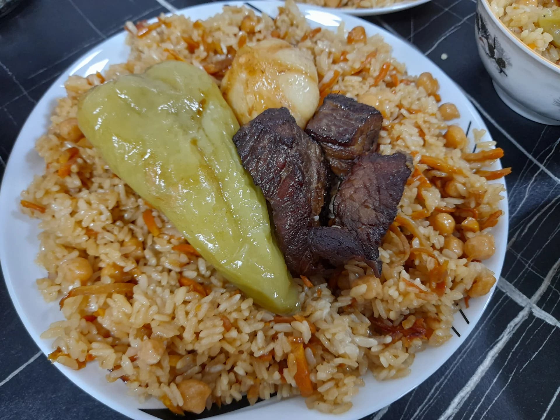 Тарелка вареного риса с мясом и овощами