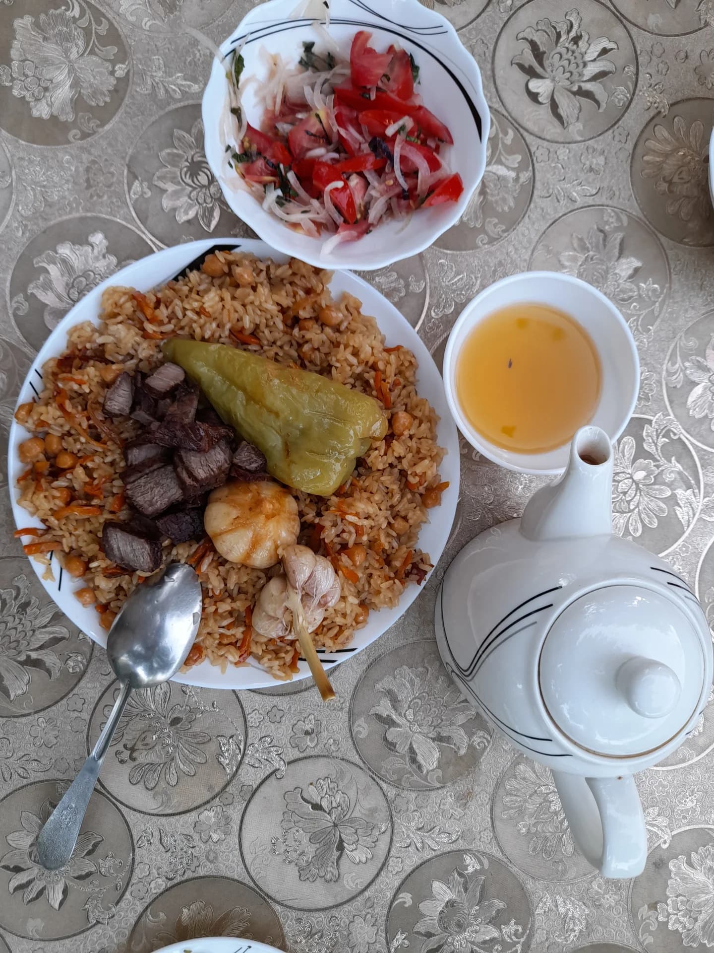 Традиционный плов, подаваемый с салатом и чаем