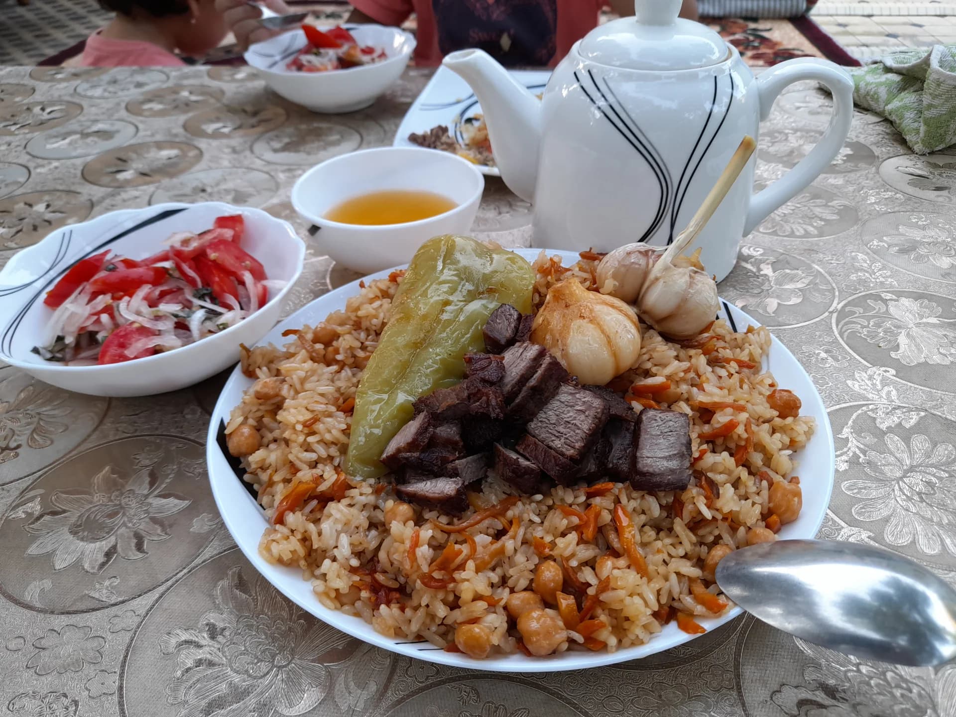 Традиционный плов, подаваемый на тарелке с мясом и овощами