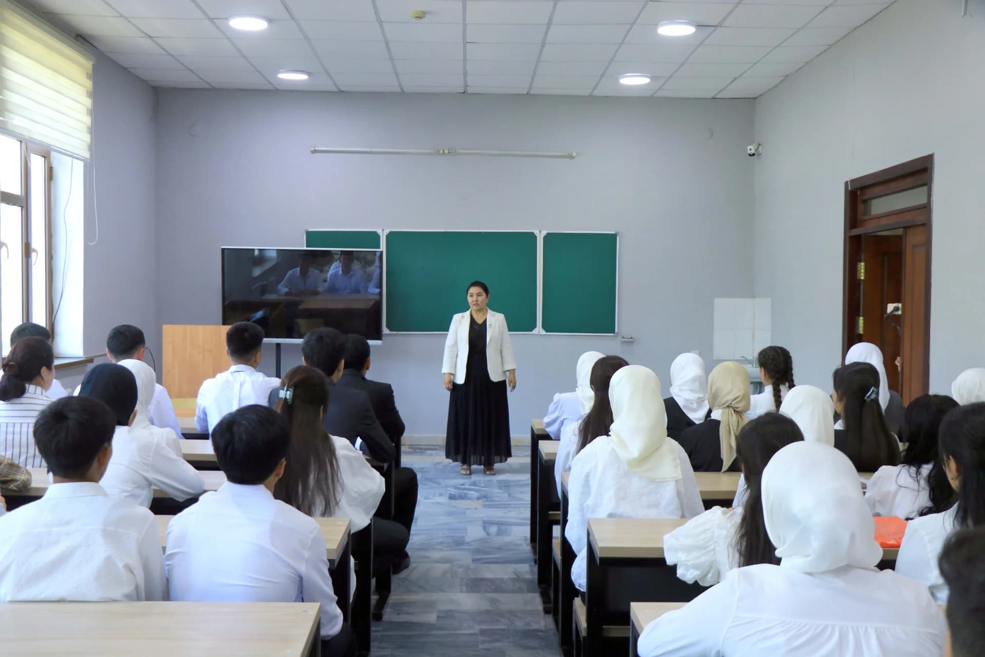 Преподаватель, стоящий перед учащимися в классе