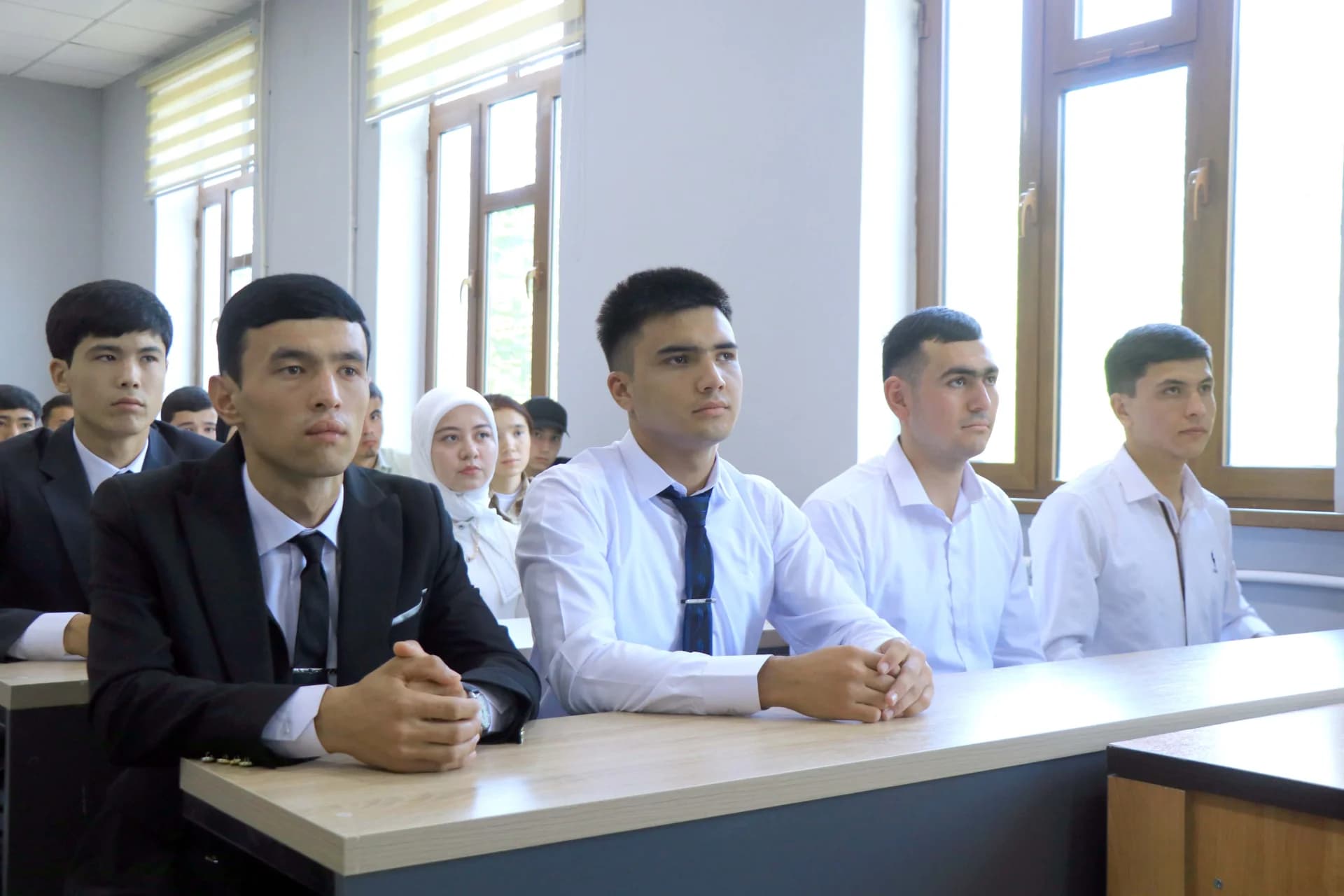 Учащиеся, сидящие за партами в классе