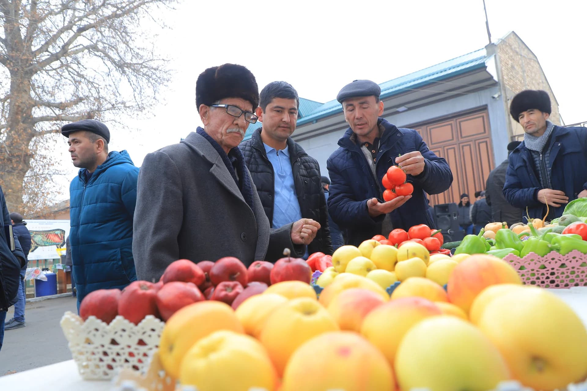 Мужчины проверяют продукты на прилавке открытого рынка