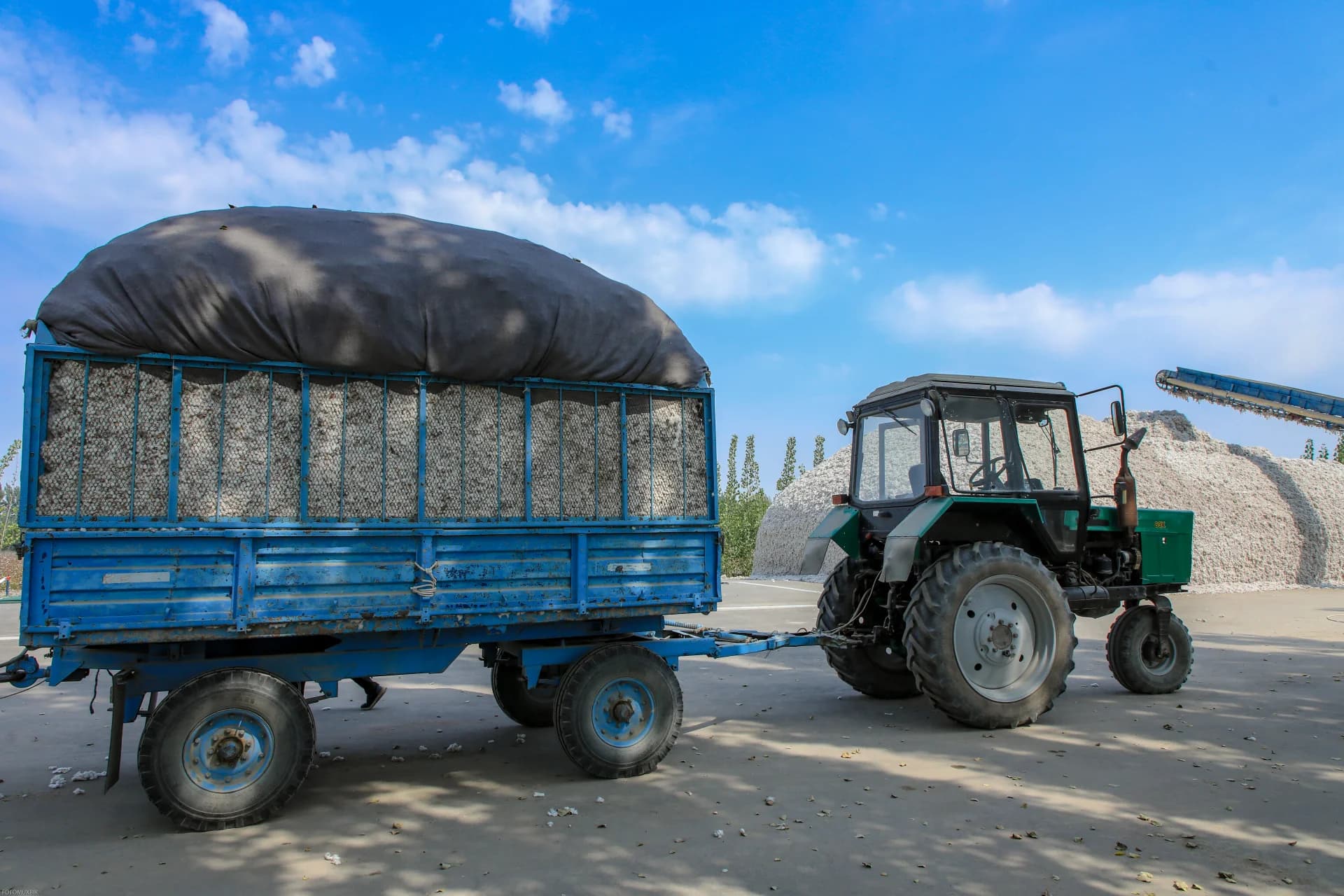 Tractor hauling a loaded trailer with harvested crops