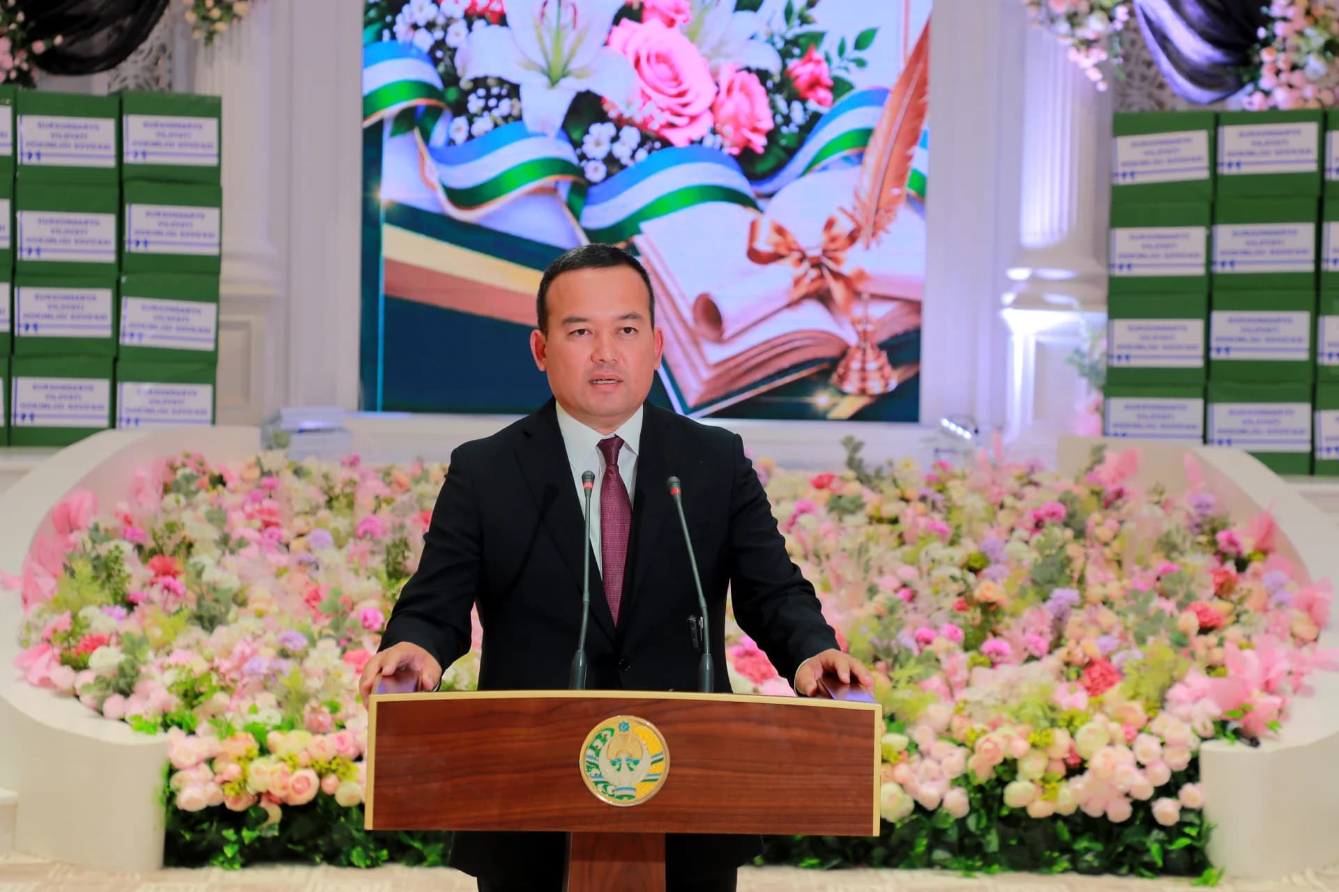 Man speaking at a podium in a decorated hall